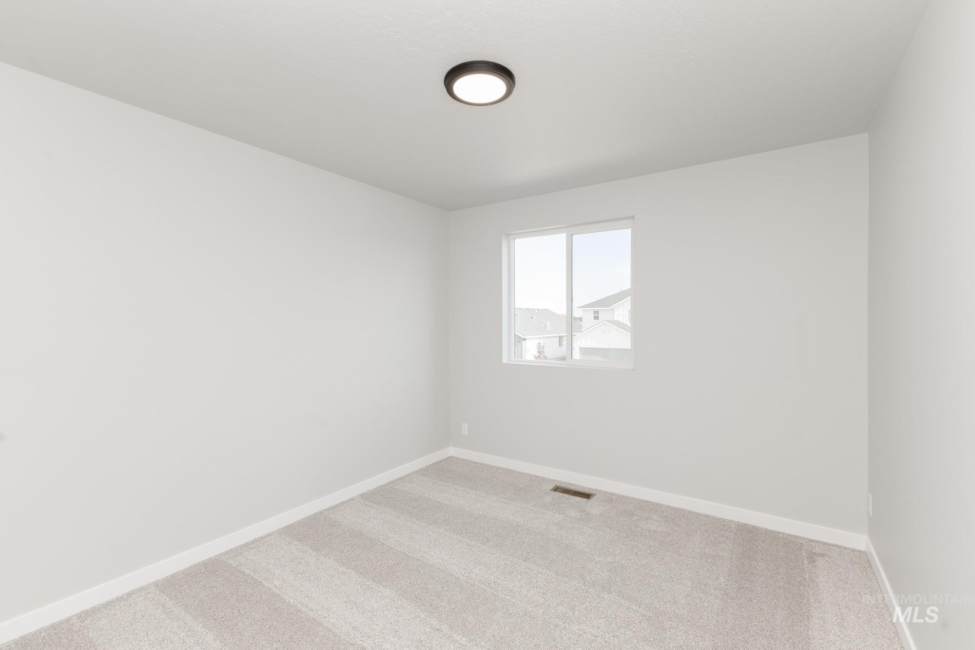 Unfurnished room featuring light colored carpet and baseboards