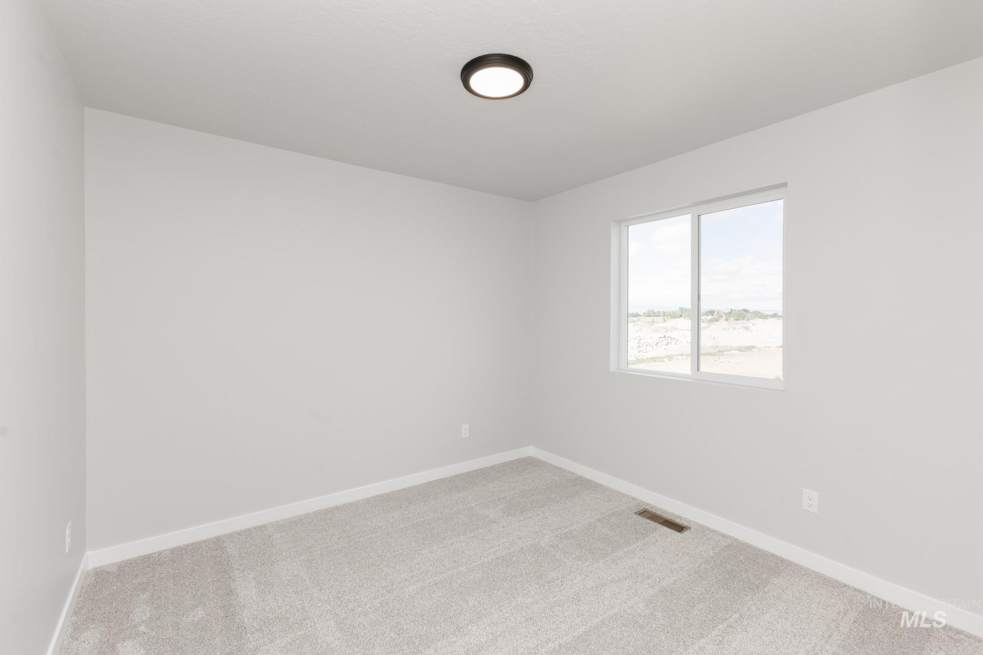 Carpeted spare room with baseboards