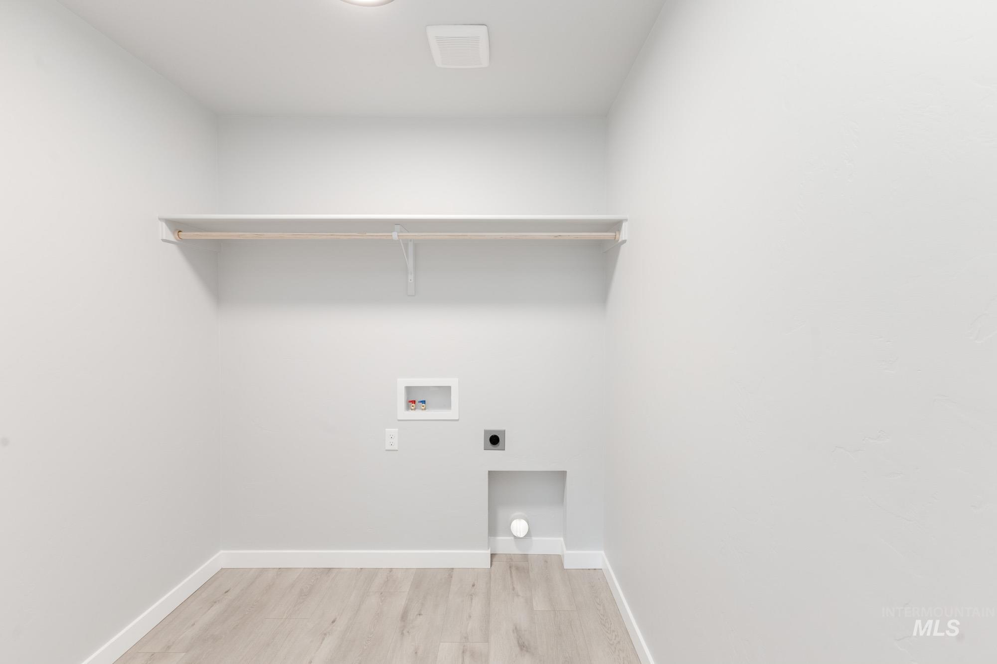 Washroom with washer hookup, electric dryer hookup, and light wood-style flooring