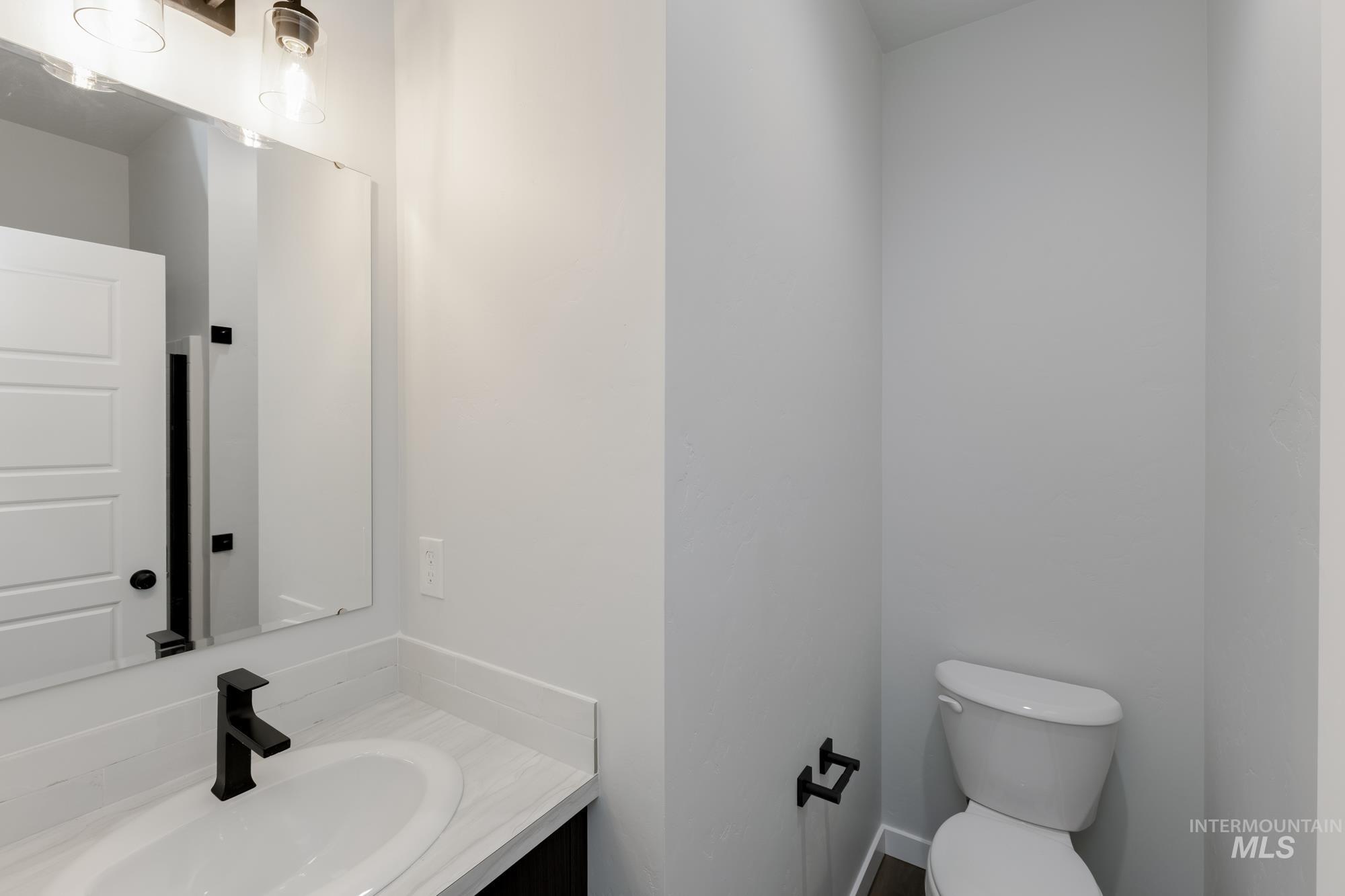 Half bathroom featuring vanity and toilet