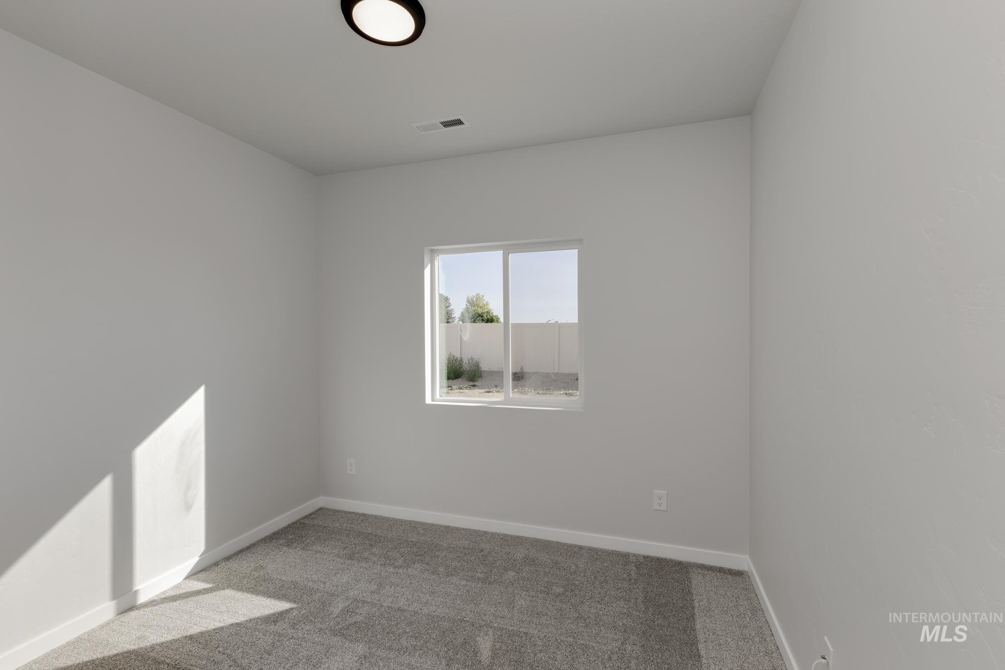 Unfurnished room with light colored carpet and baseboards
