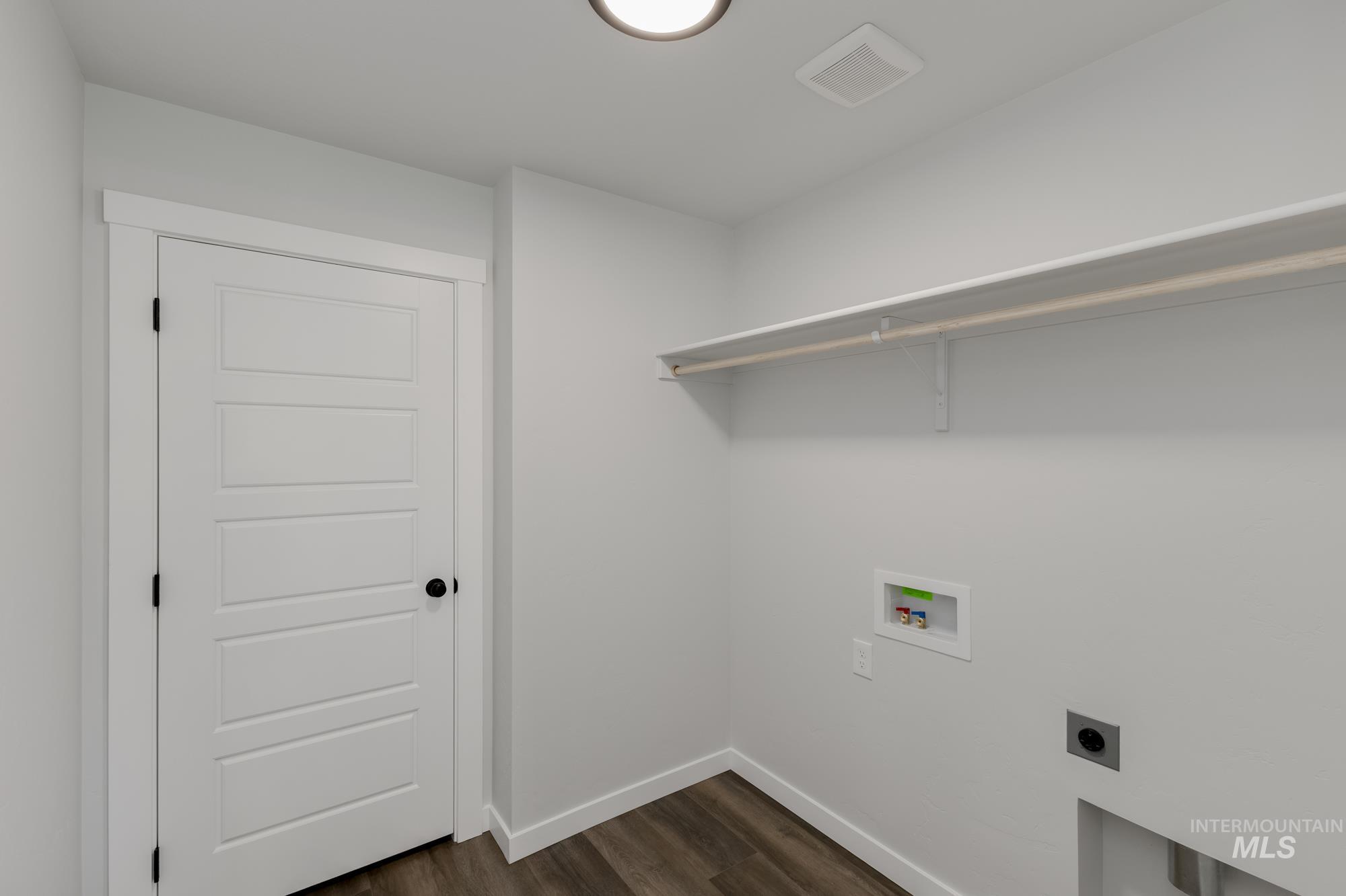 Laundry room featuring dark wood finished floors, hookup for a washing machine, and hookup for an electric dryer