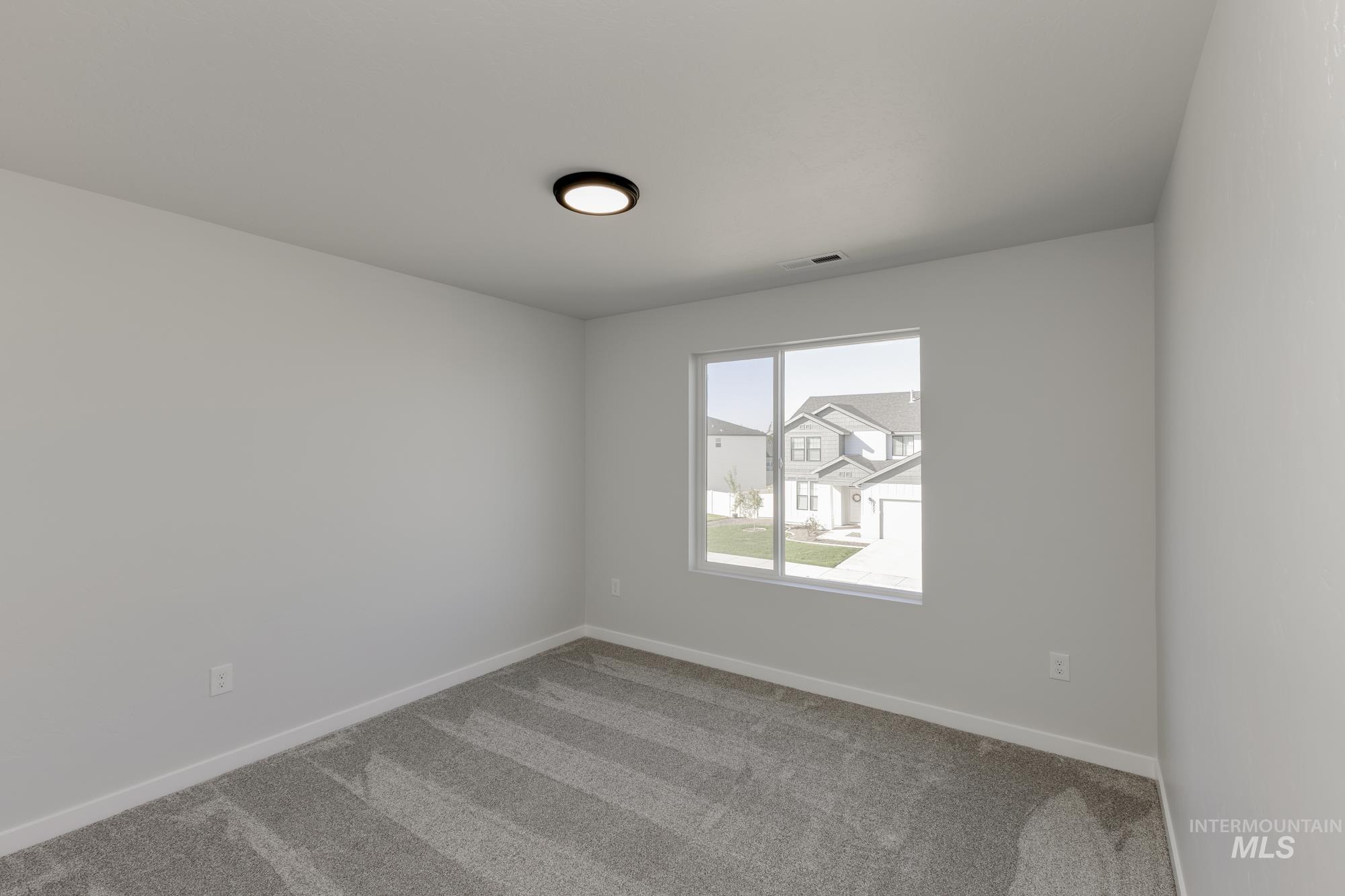 Carpeted spare room with baseboards