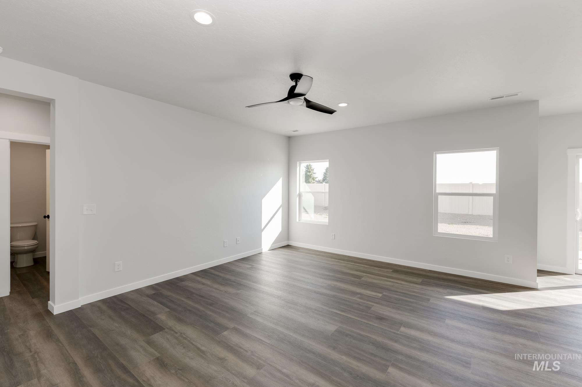 Unfurnished room featuring plenty of natural light, dark wood-style flooring, recessed lighting, and a ceiling fan