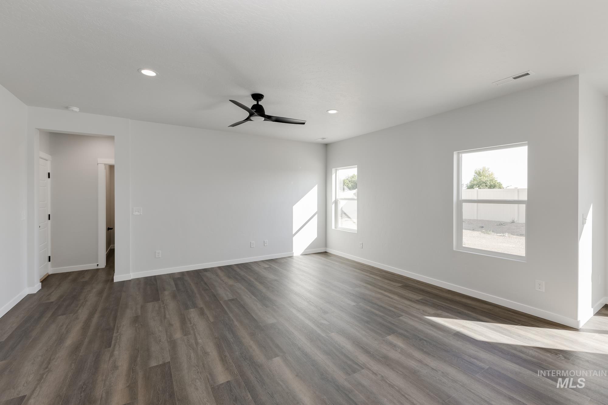 Spare room featuring dark wood-type flooring, recessed lighting, and ceiling fan