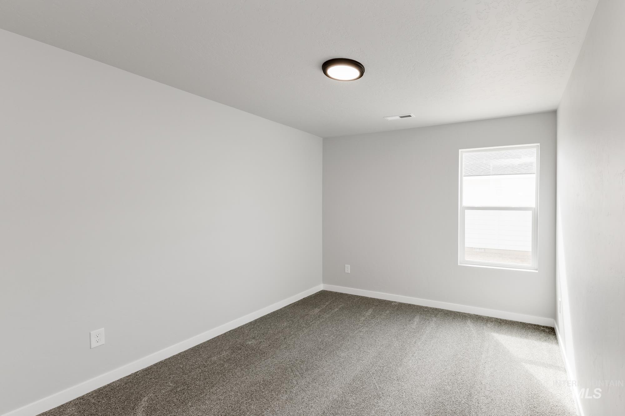 Carpeted empty room with baseboards