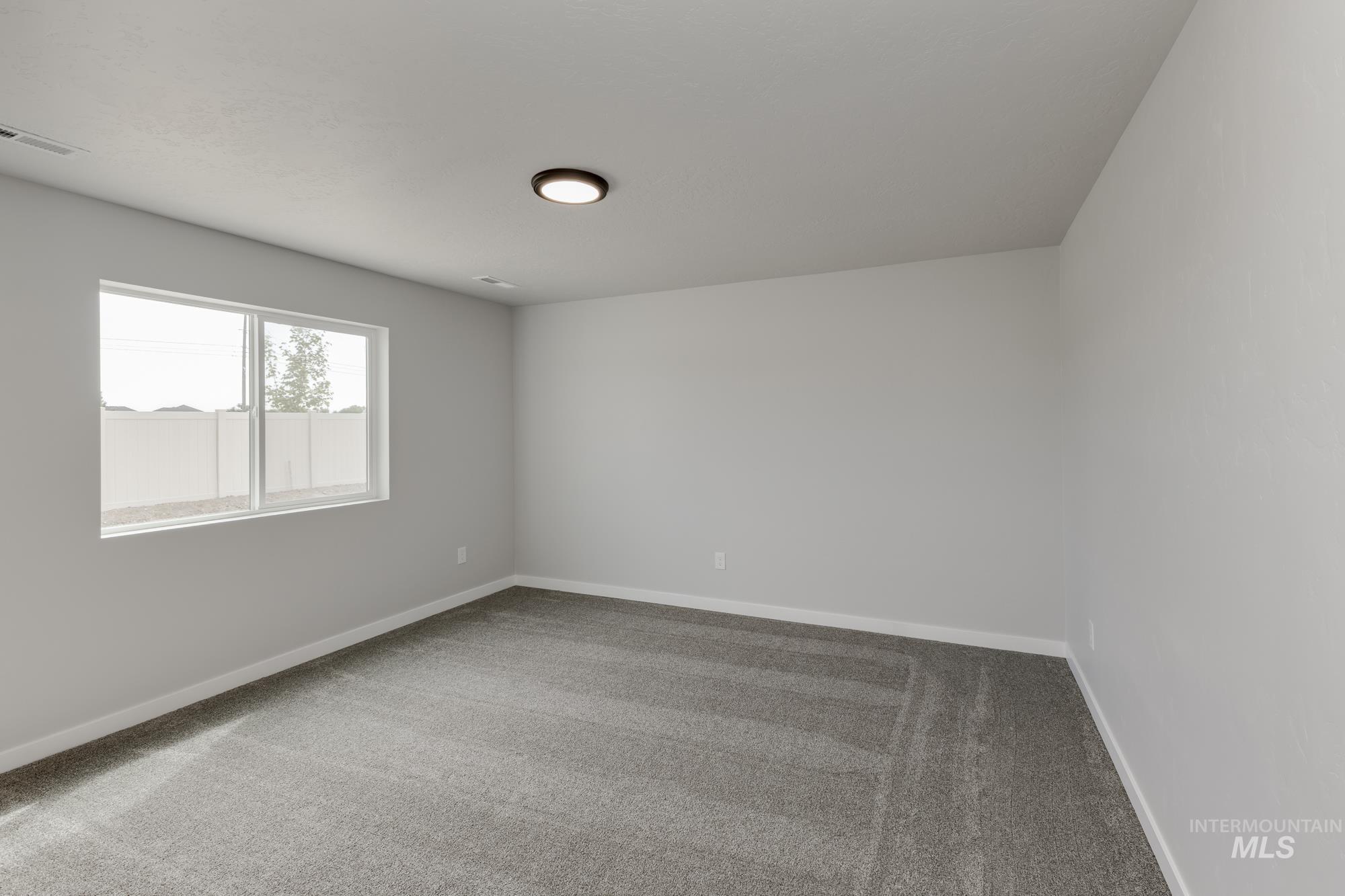 Empty room featuring light colored carpet and baseboards