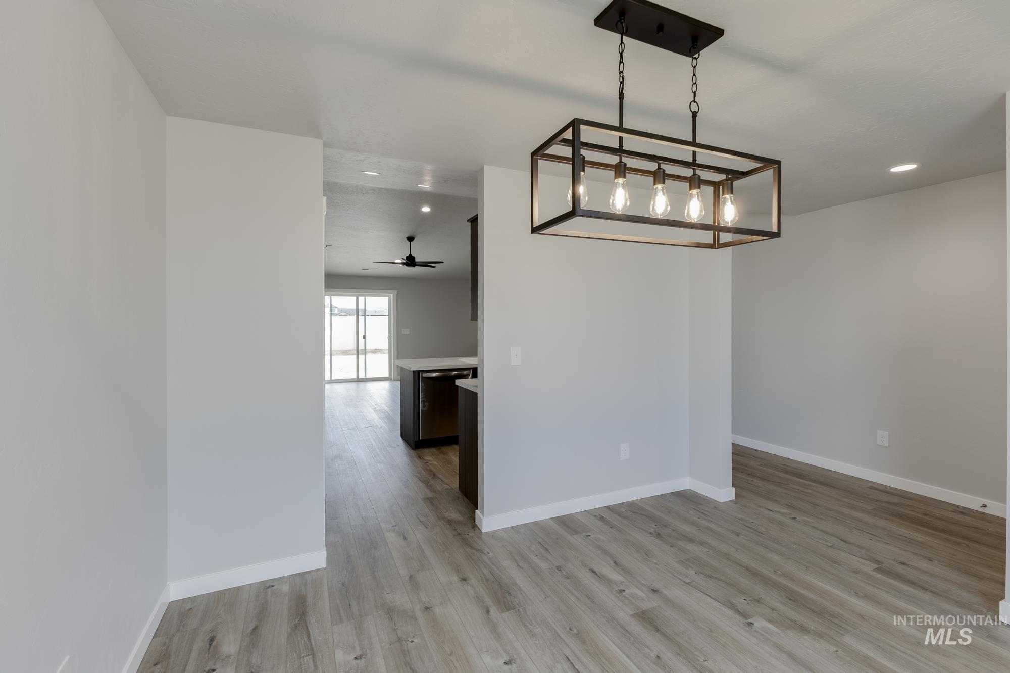 Unfurnished dining area with light wood-type flooring, a ceiling fan, and recessed lighting