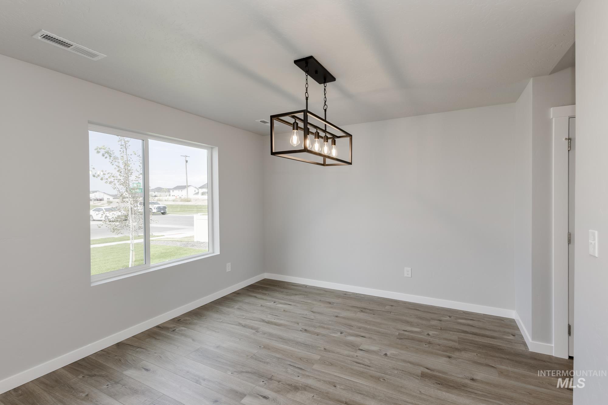 Unfurnished dining area featuring light wood-style floors and a chandelier