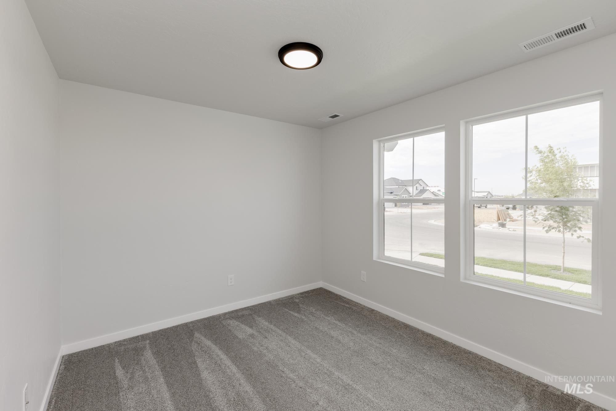 Spare room featuring carpet floors and baseboards