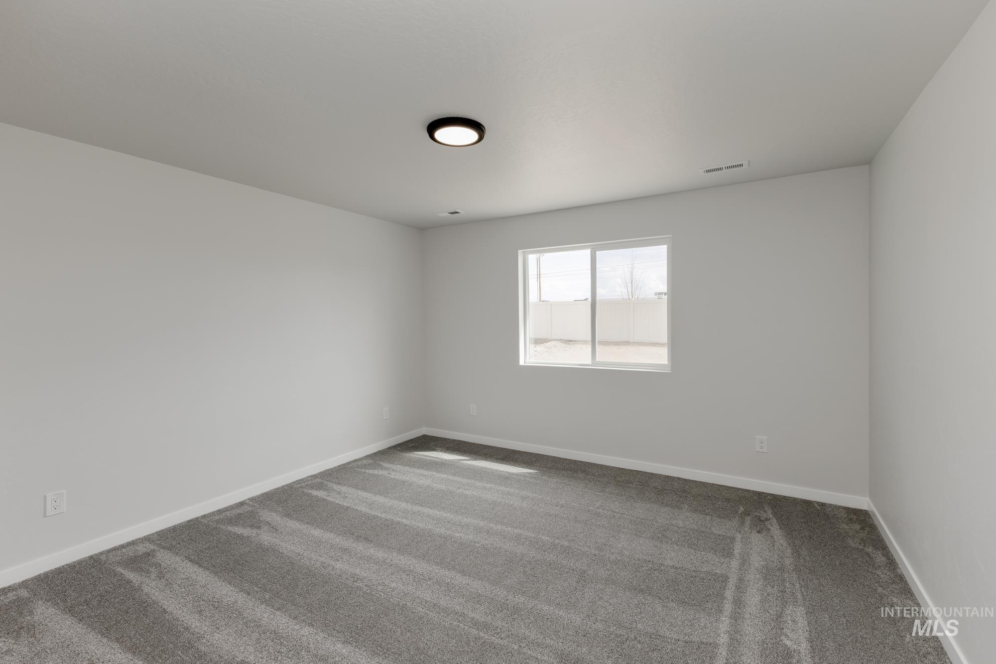 Empty room featuring carpet flooring and baseboards