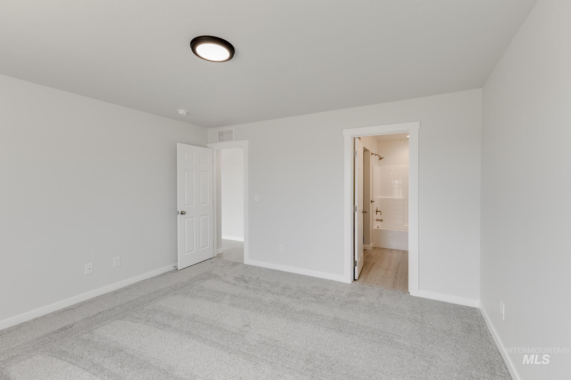 Unfurnished bedroom featuring carpet floors and ensuite bath
