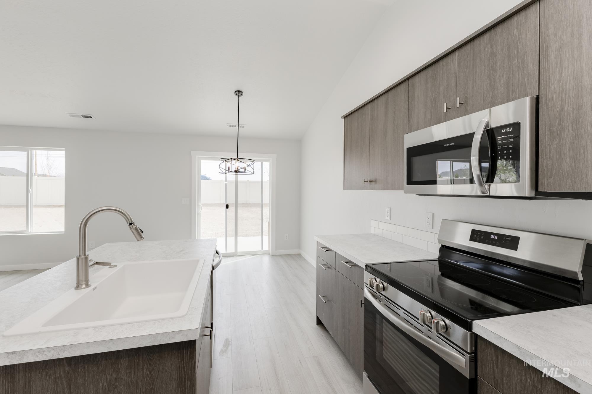 Kitchen with stainless steel appliances, light countertops, and healthy amount of natural light