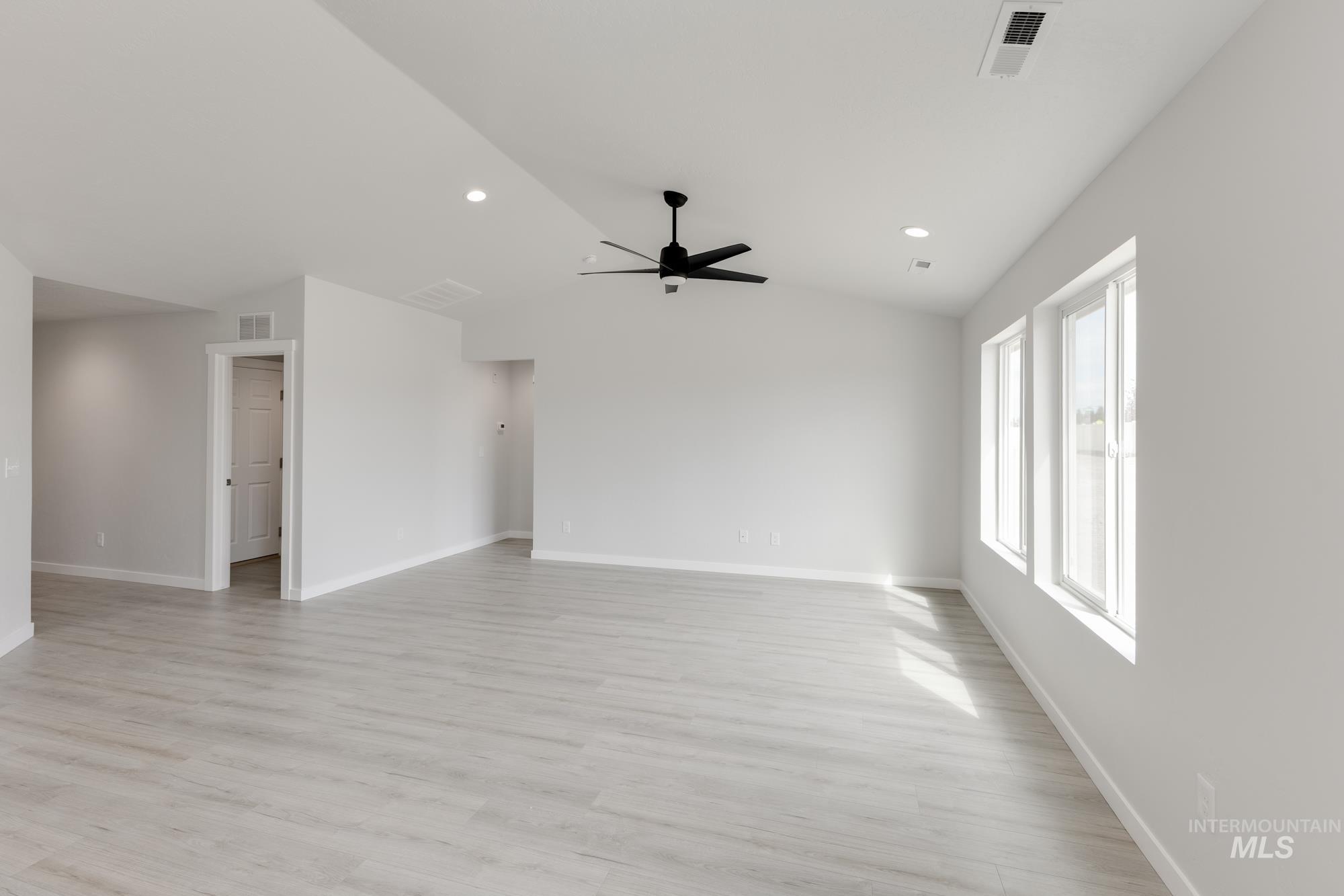 Empty room featuring light wood-type flooring, lofted ceiling, recessed lighting, and a ceiling fan