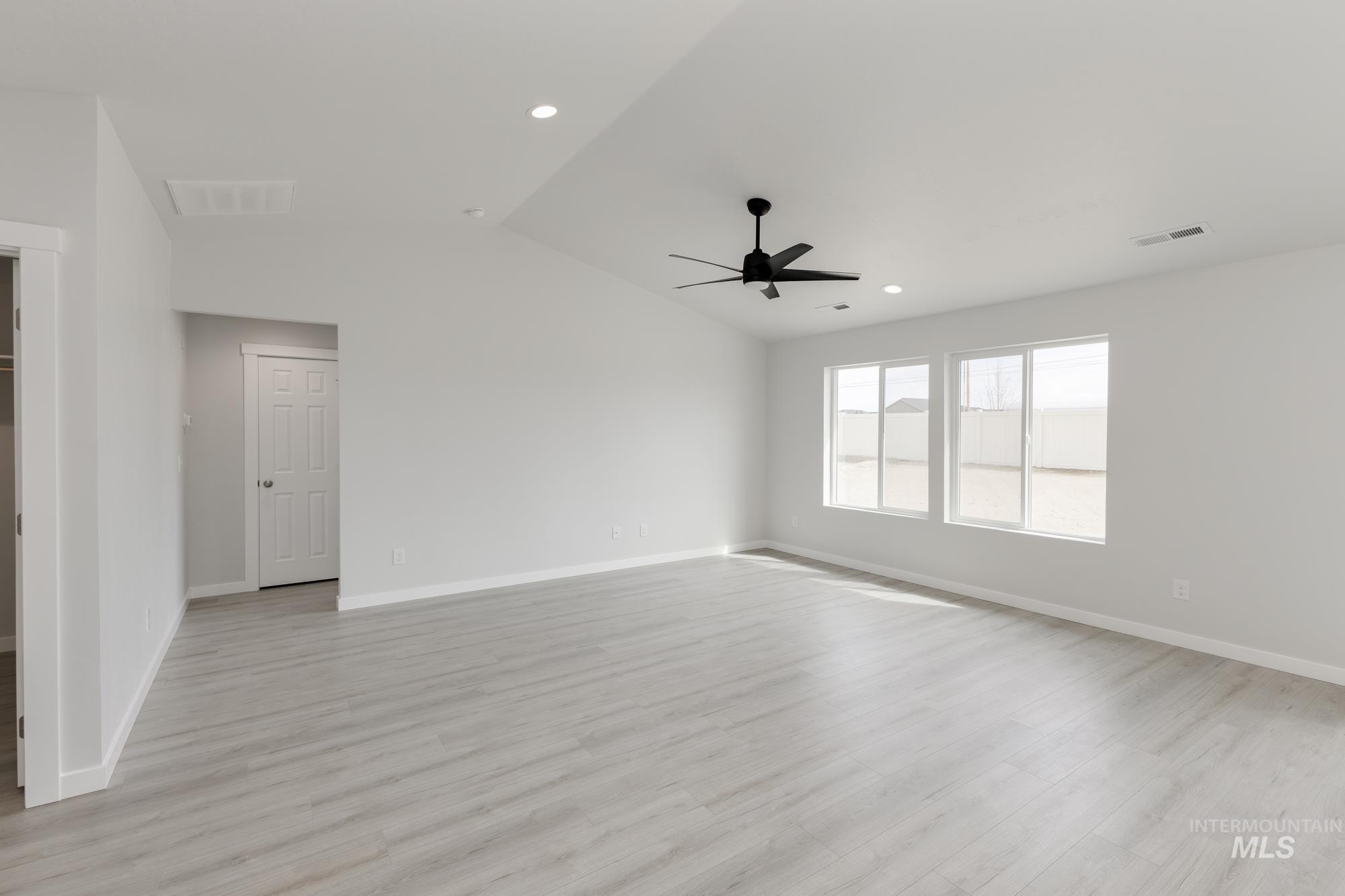 Spare room with light wood-style flooring, lofted ceiling, recessed lighting, and ceiling fan