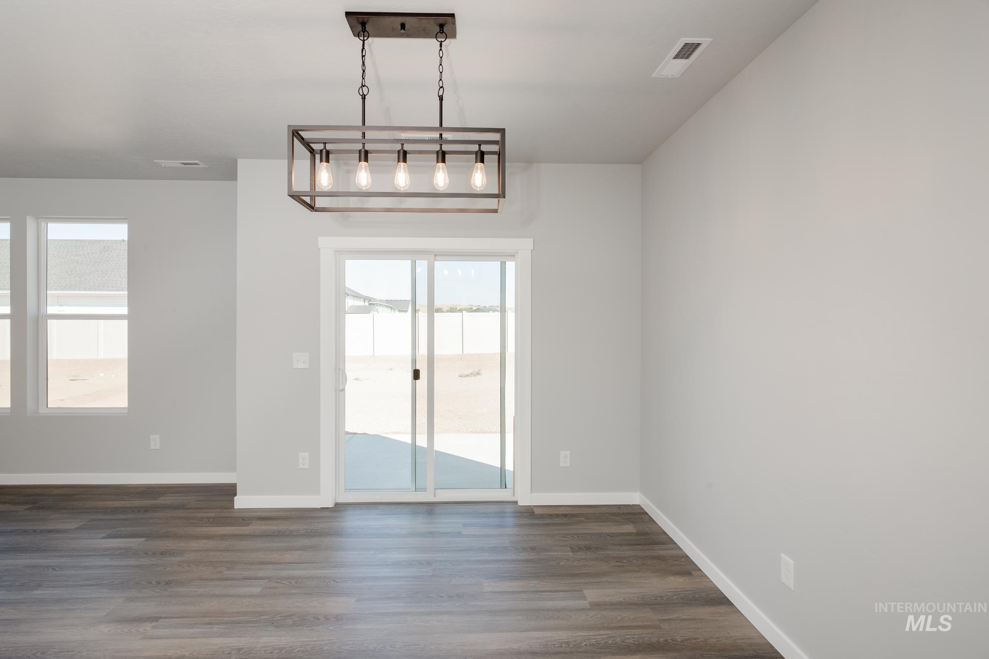 Unfurnished dining area with dark wood finished floors