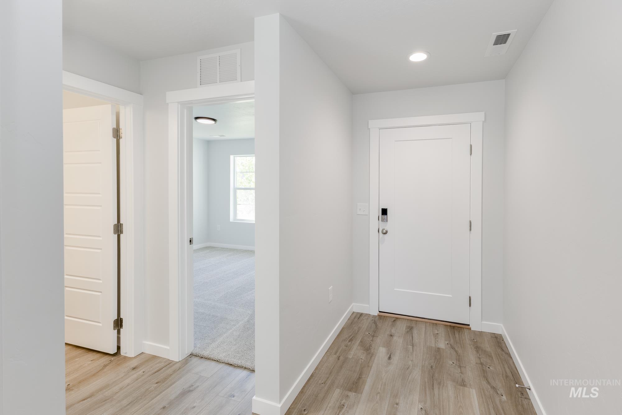 Entrance foyer with light wood-style flooring and recessed lighting