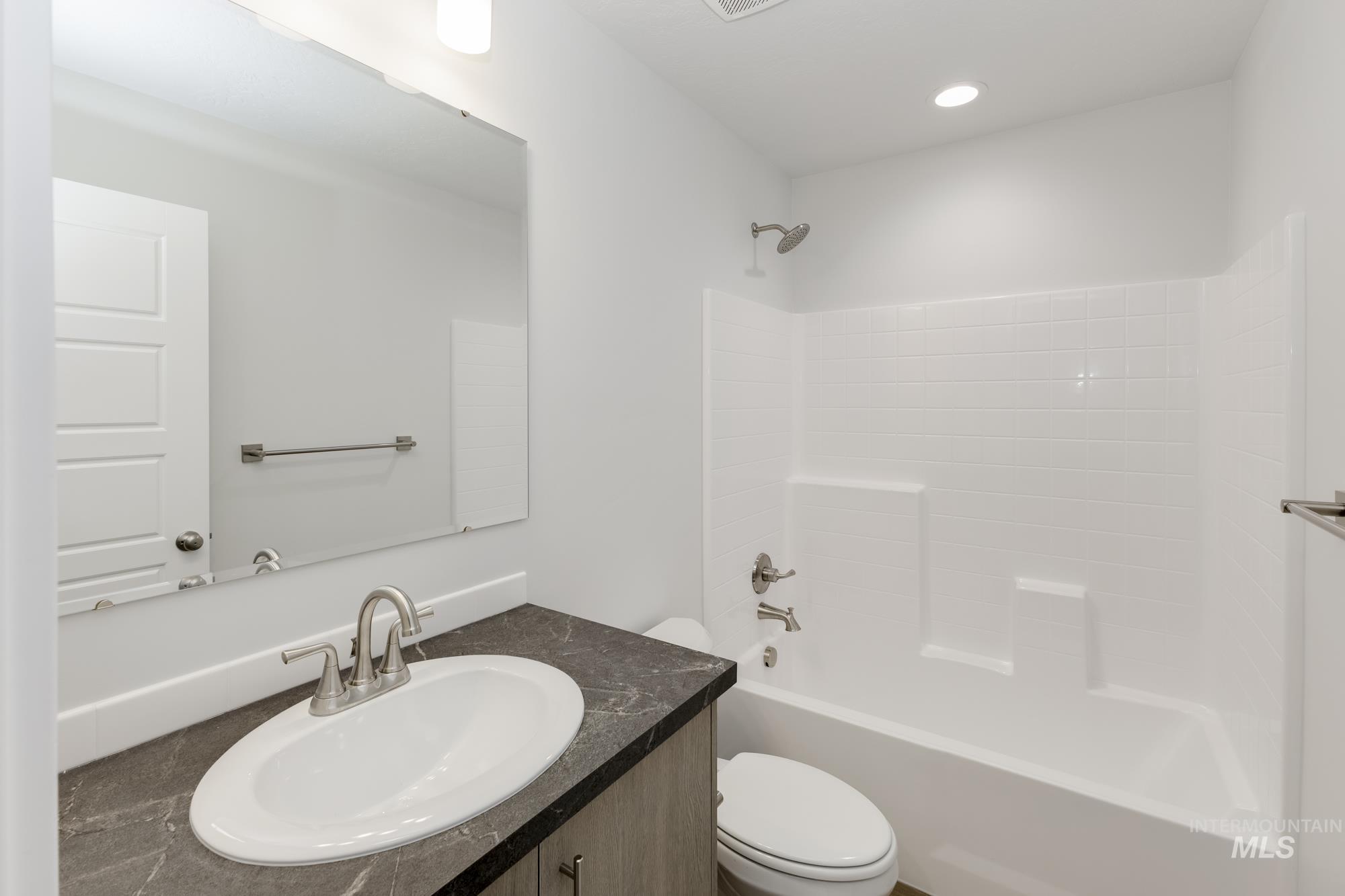 Full bathroom featuring vanity, washtub / shower combination, and recessed lighting