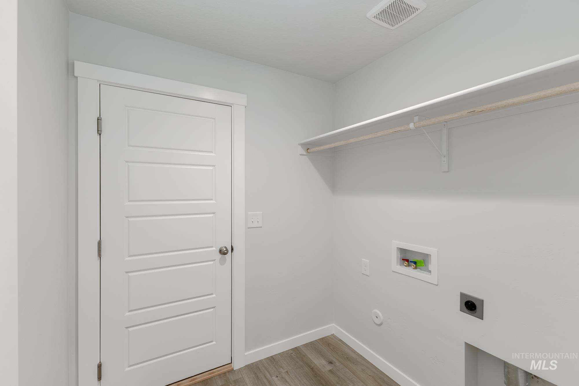 Laundry area featuring light wood-type flooring, hookup for an electric dryer, and washer hookup