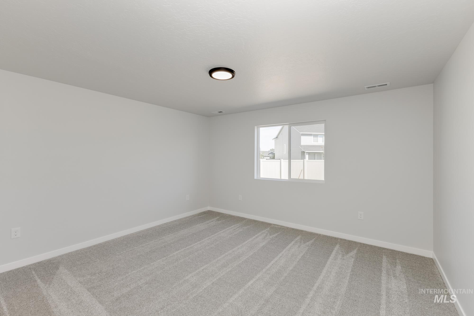Carpeted spare room with baseboards