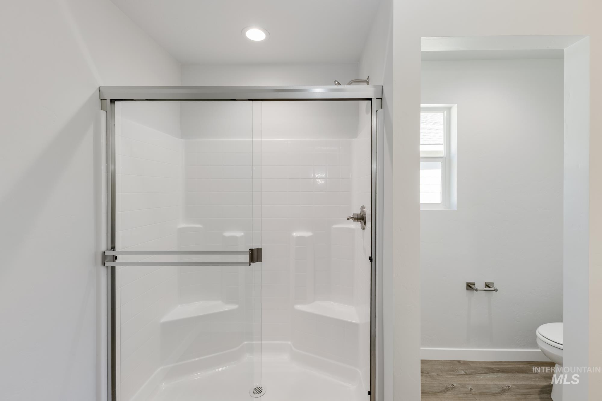 Bathroom featuring a shower stall and light wood finished floors