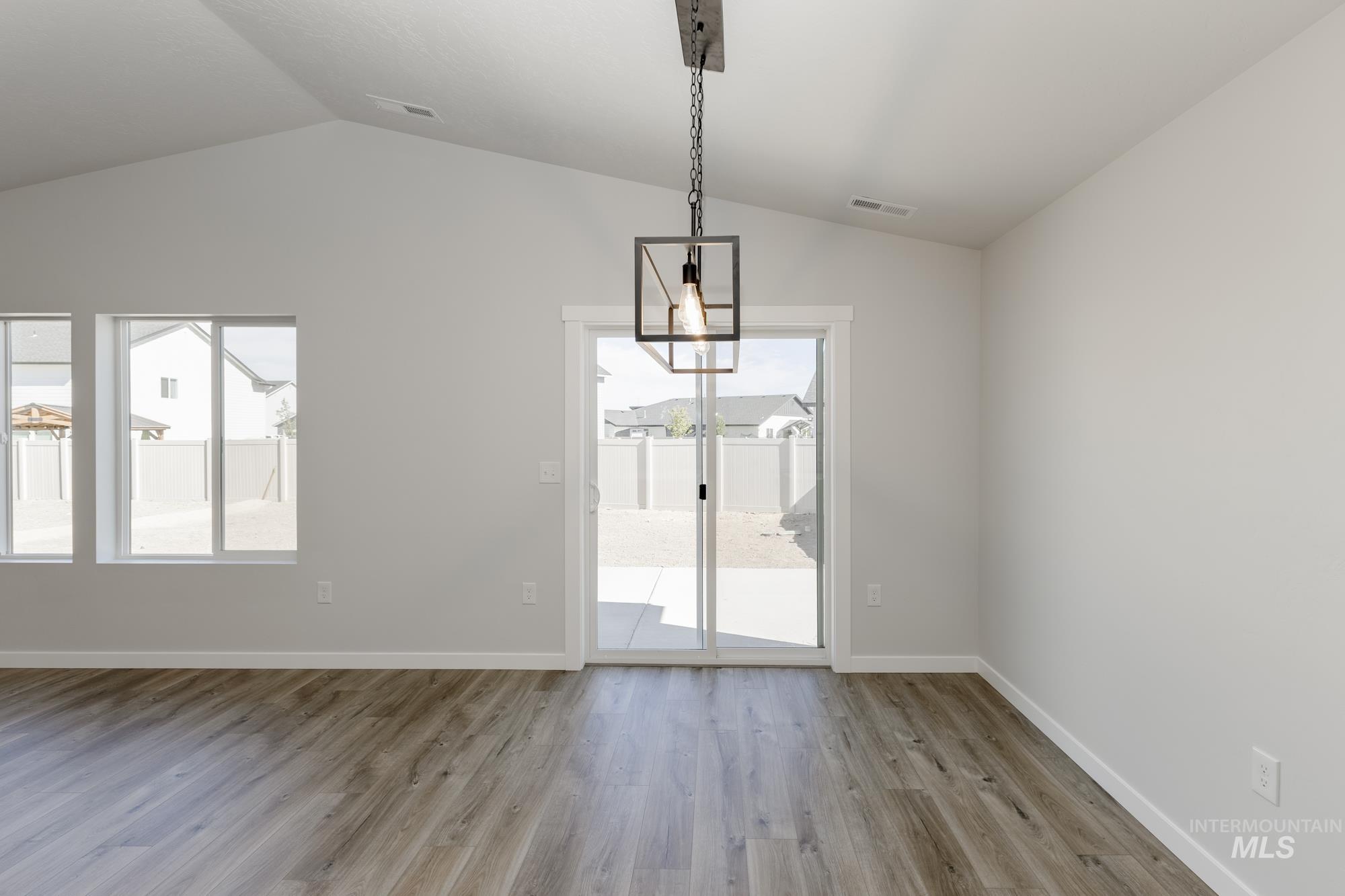 Unfurnished dining area featuring light wood-style floors and lofted ceiling