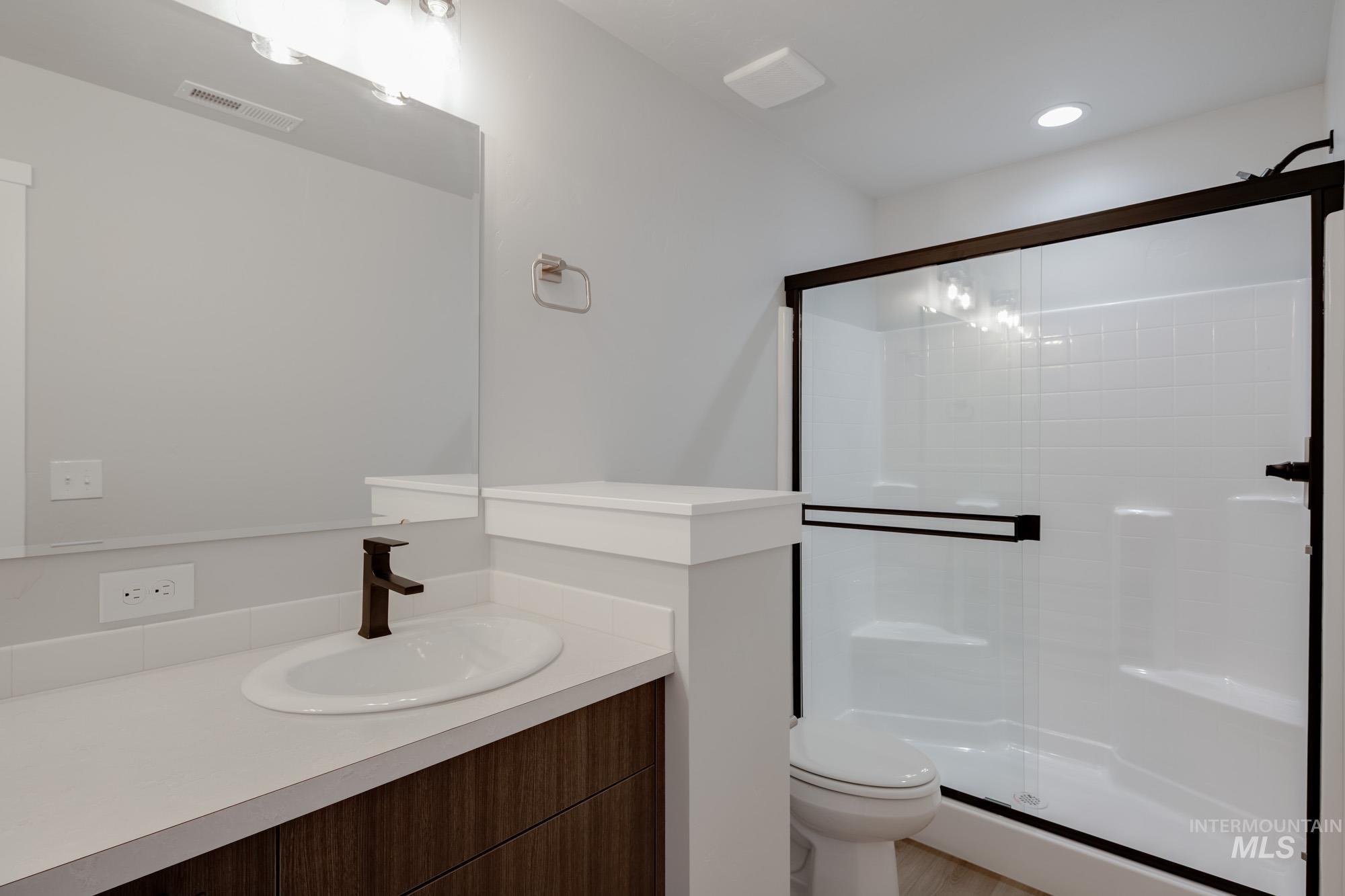 Bathroom featuring a shower stall, vanity, and recessed lighting