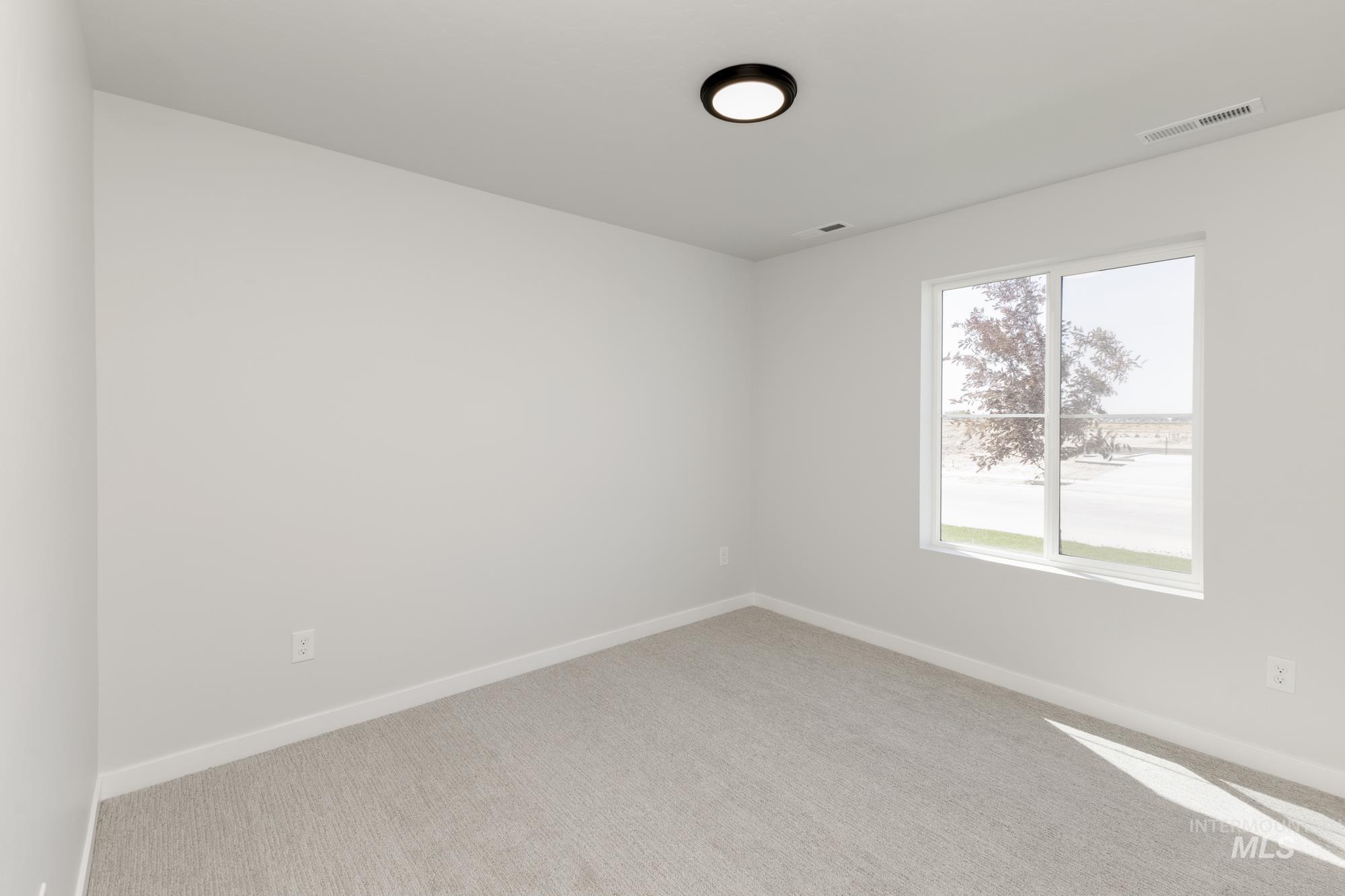 Carpeted empty room featuring baseboards