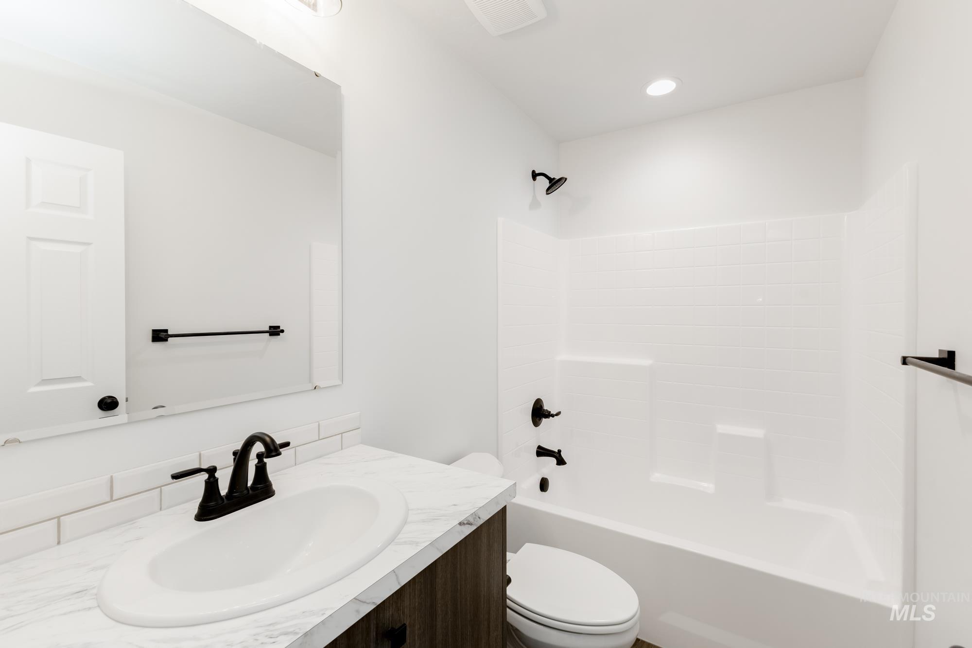 Full bath with vanity, tub / shower combination, and recessed lighting