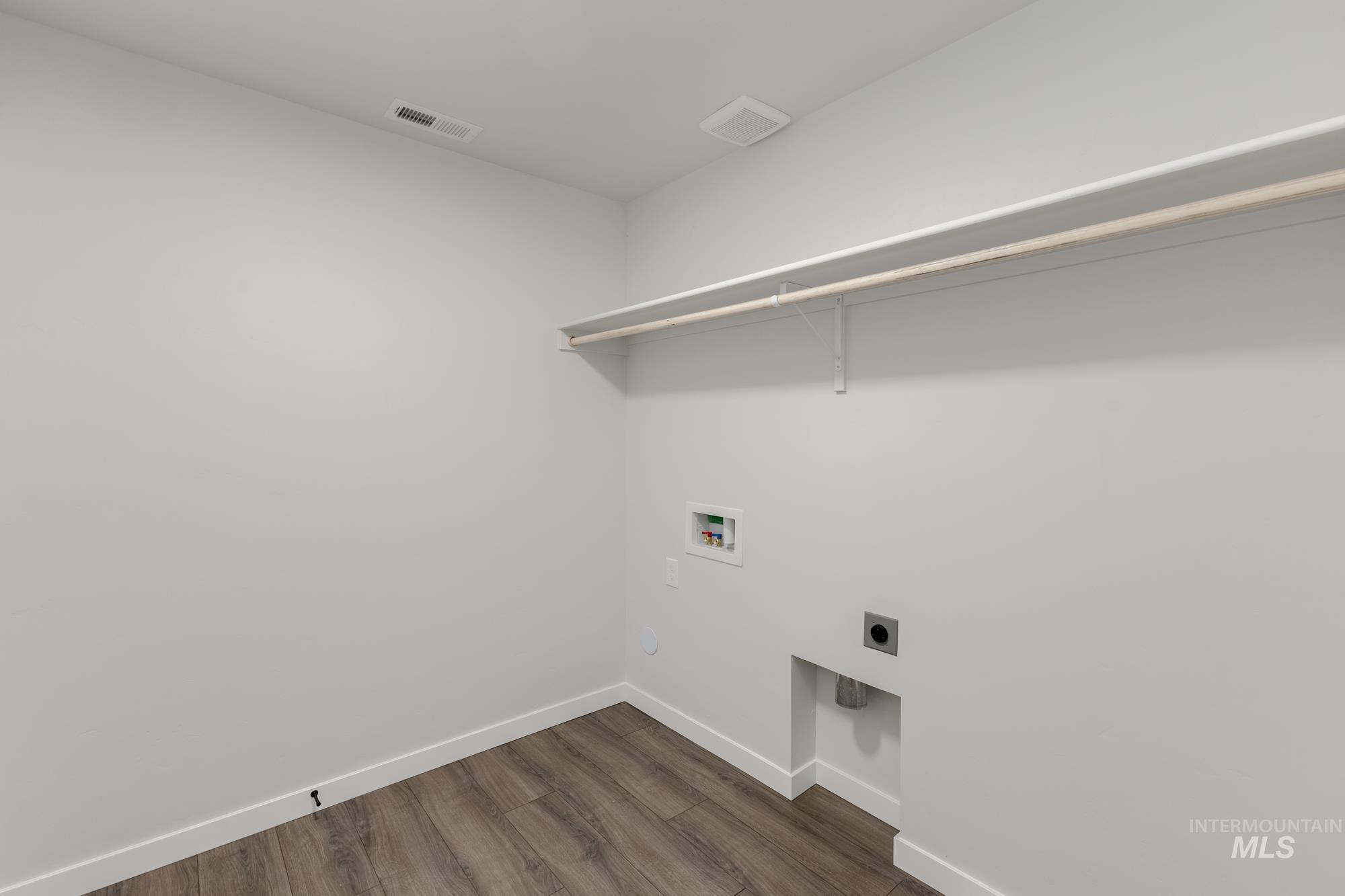 Laundry area with dark wood-style floors, electric dryer hookup, and washer hookup