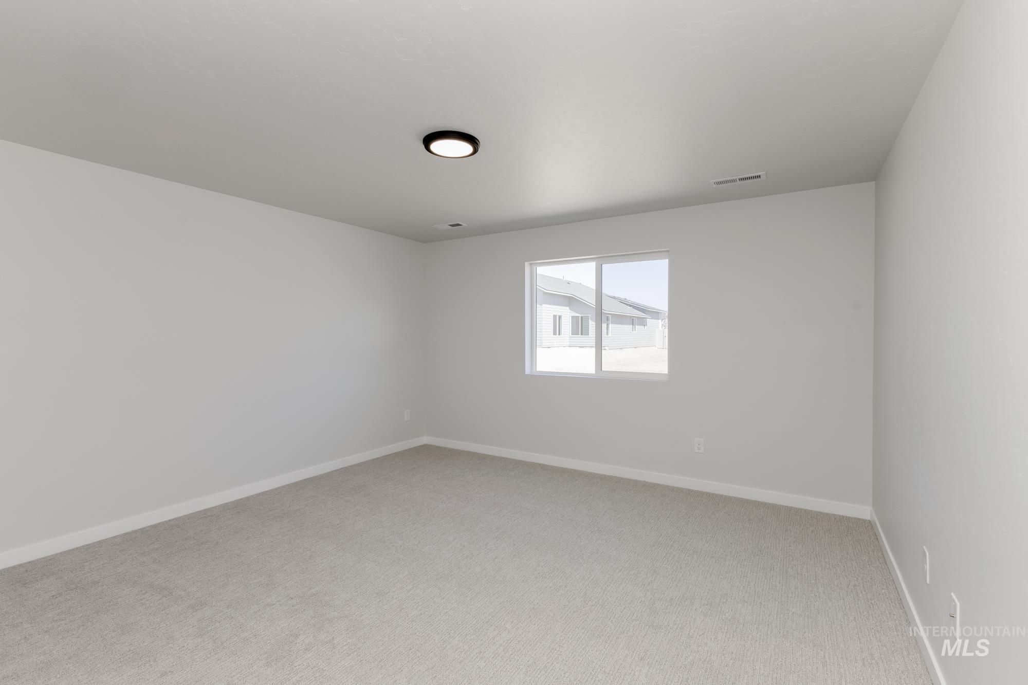 Empty room featuring light colored carpet