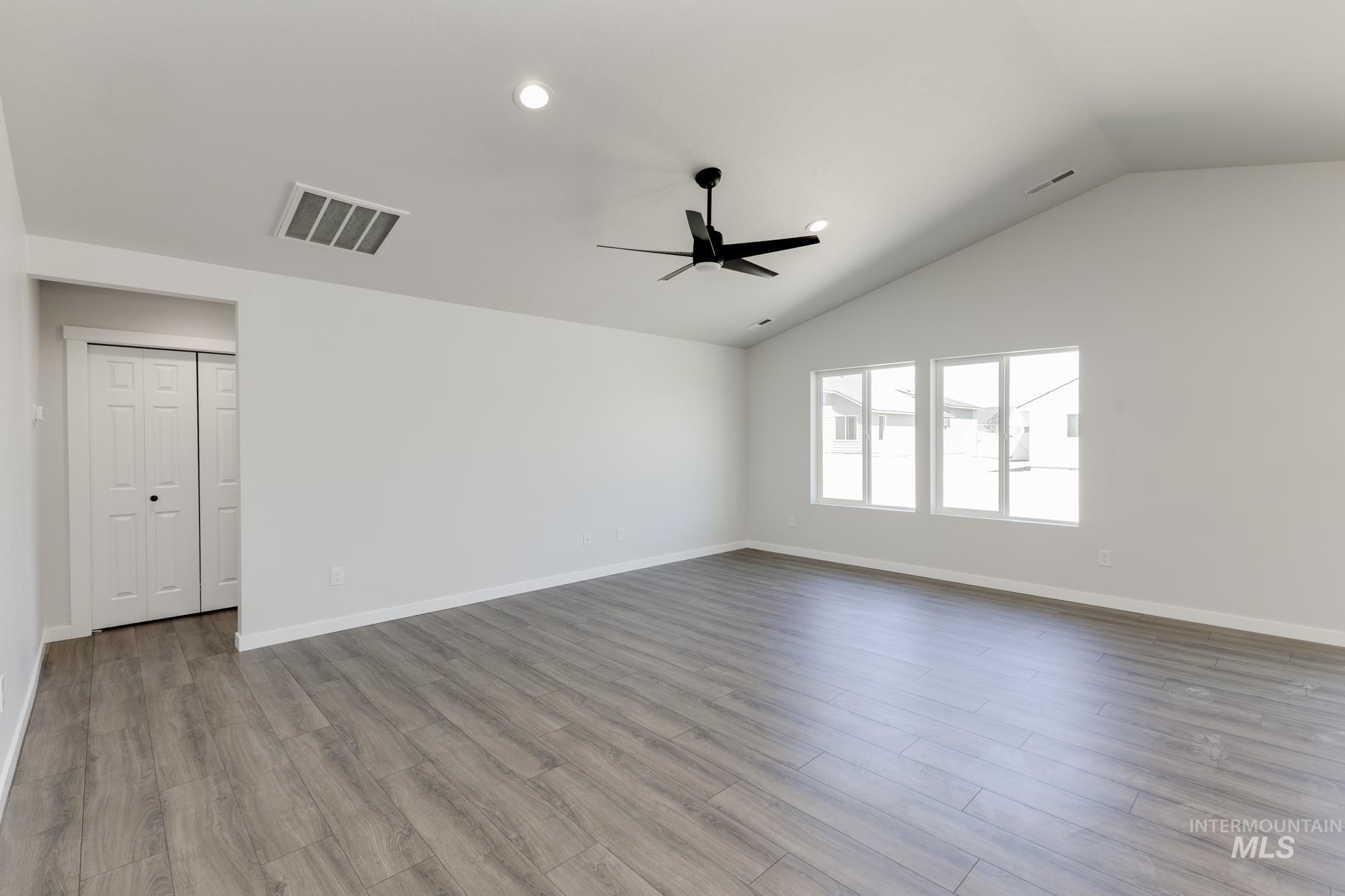 Empty room featuring wood finished floors, vaulted ceiling, recessed lighting, and a ceiling fan