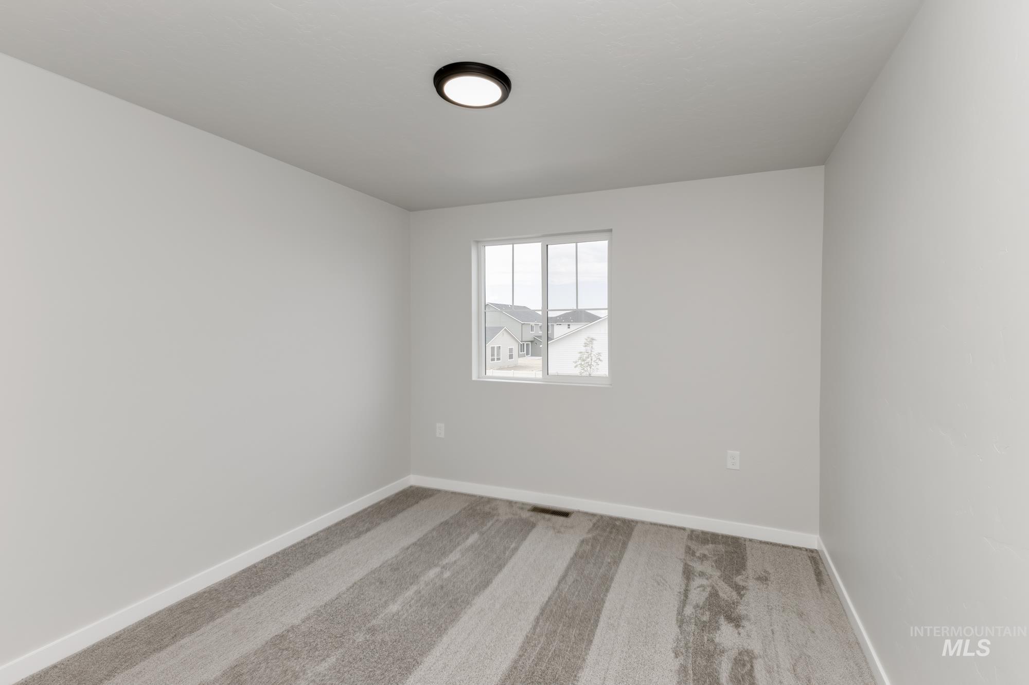 Spare room with light colored carpet and baseboards