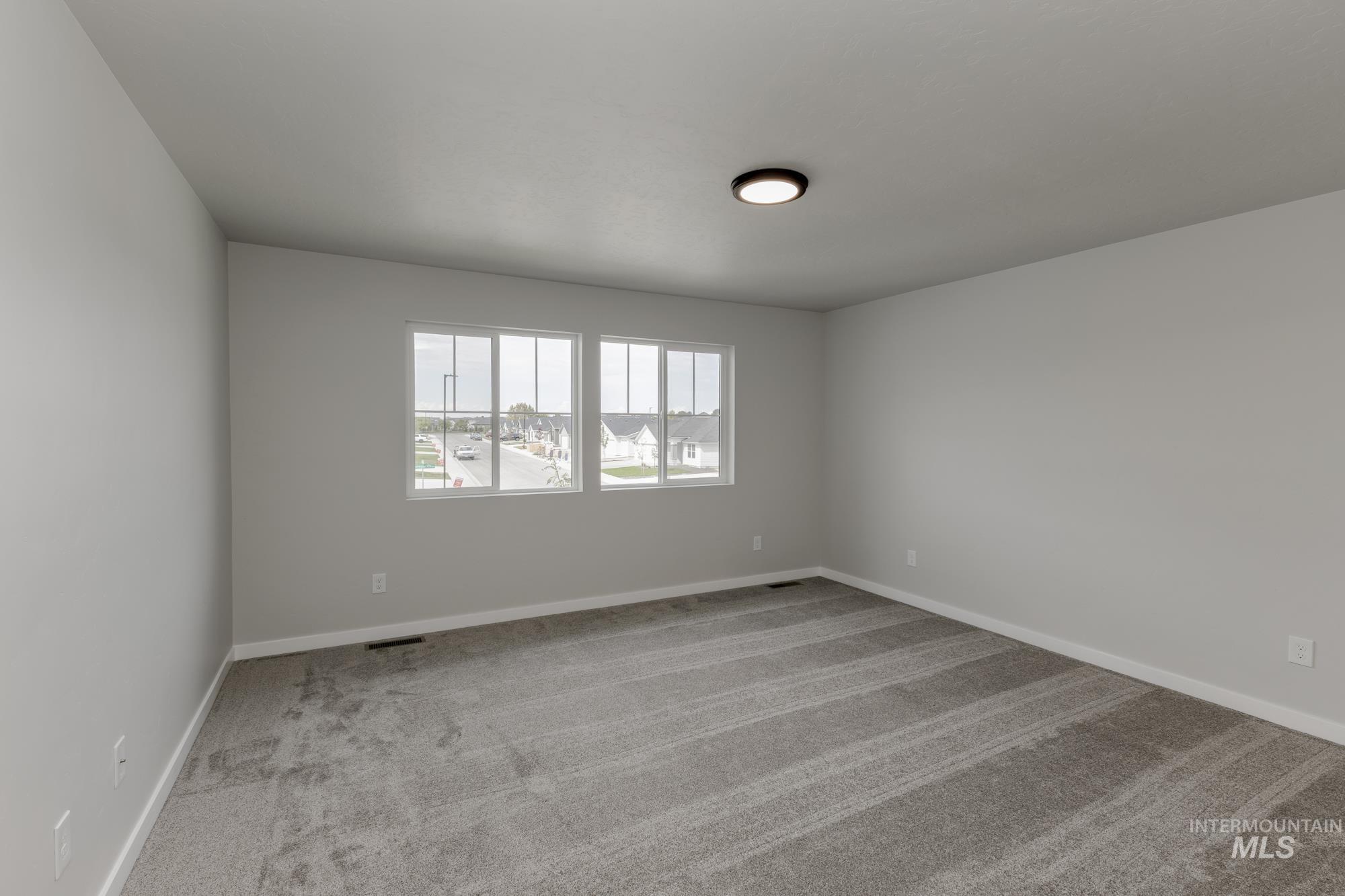Empty room featuring light colored carpet and baseboards