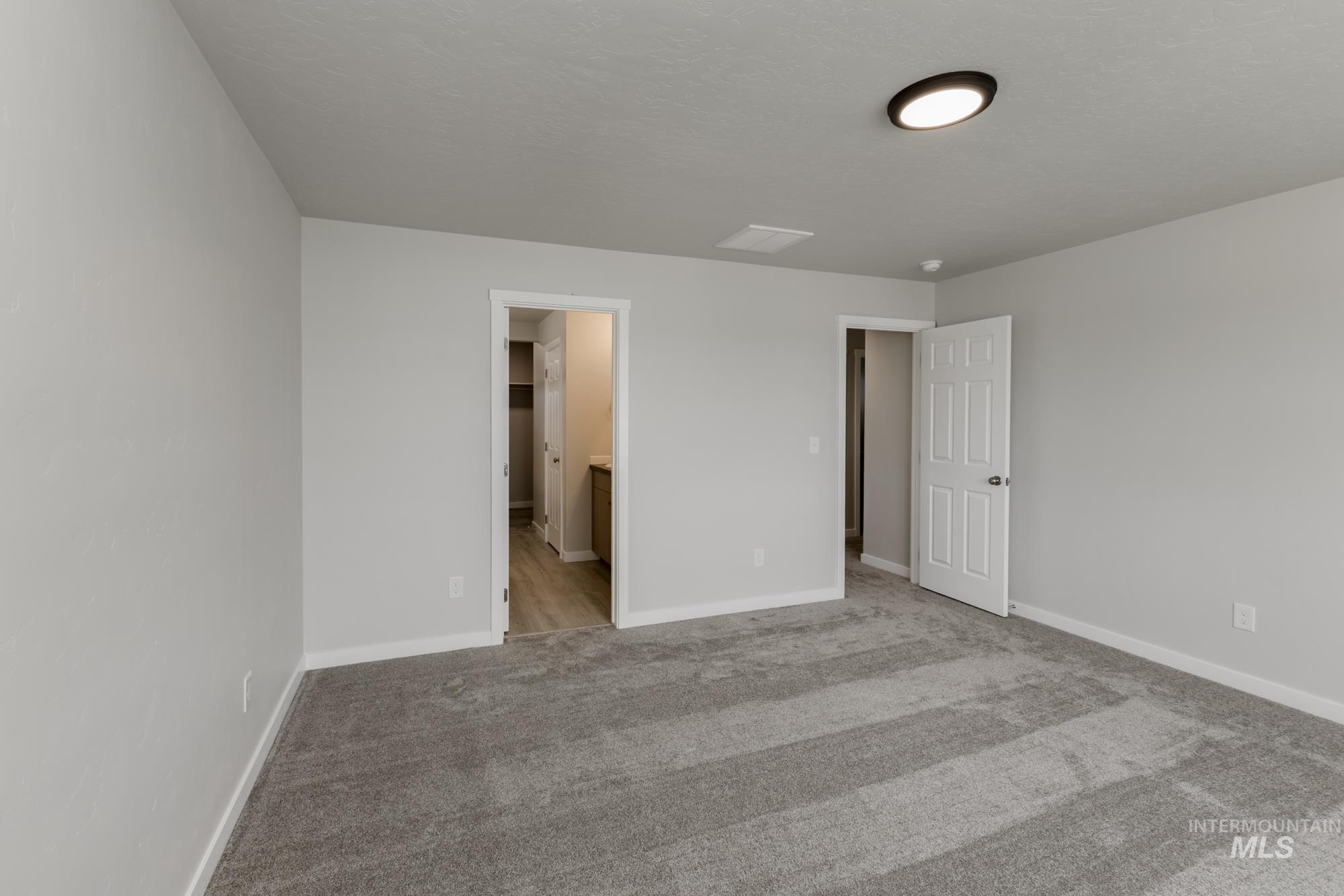 Unfurnished bedroom featuring carpet floors and ensuite bath