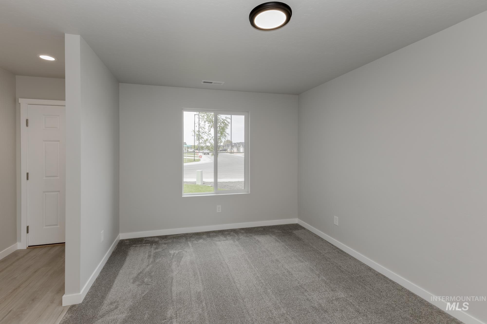 Unfurnished room with baseboards and light colored carpet