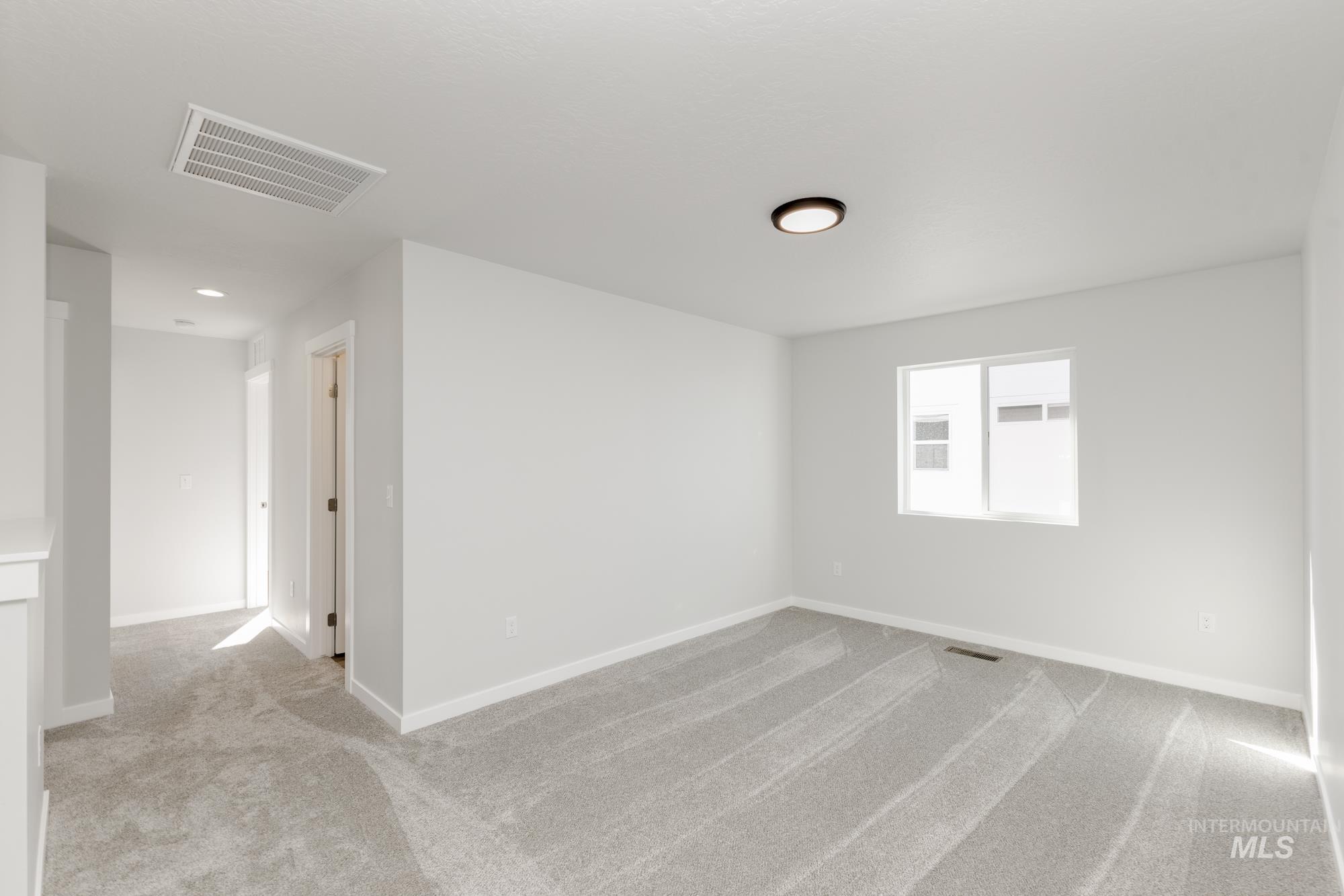 Carpeted empty room featuring baseboards