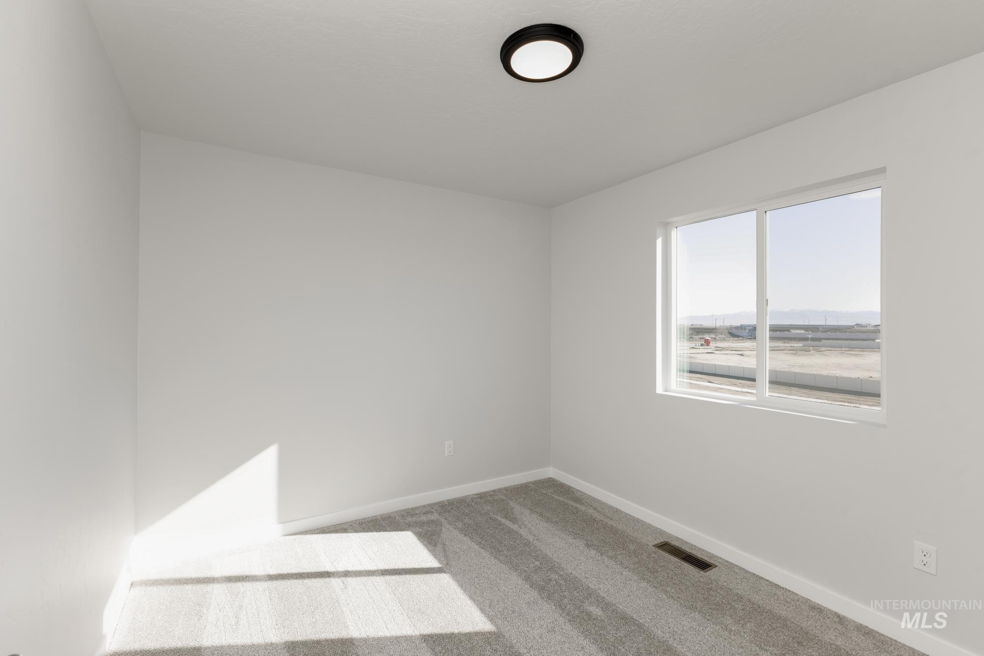 Spare room featuring baseboards and carpet flooring