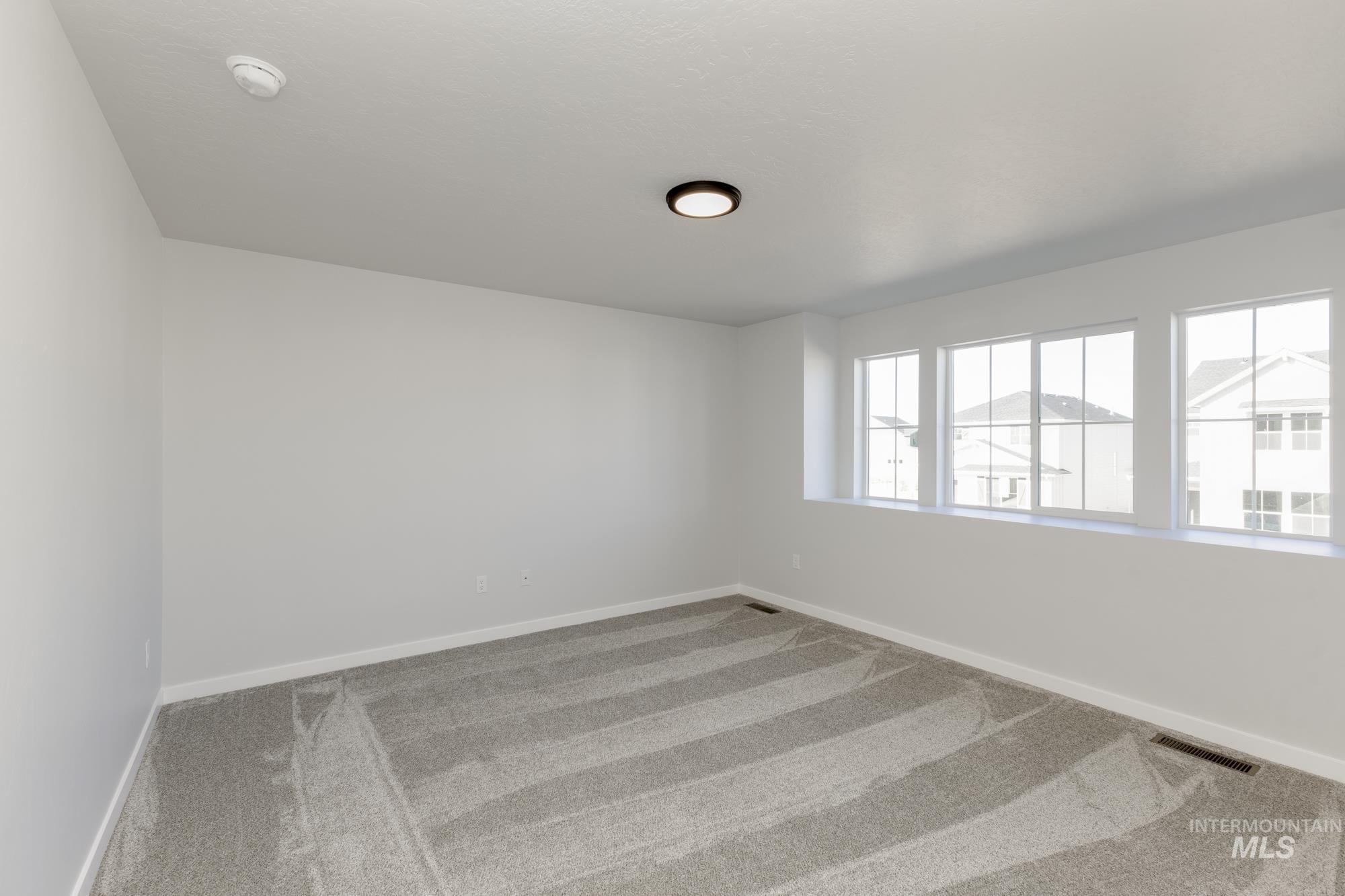 Carpeted empty room with baseboards