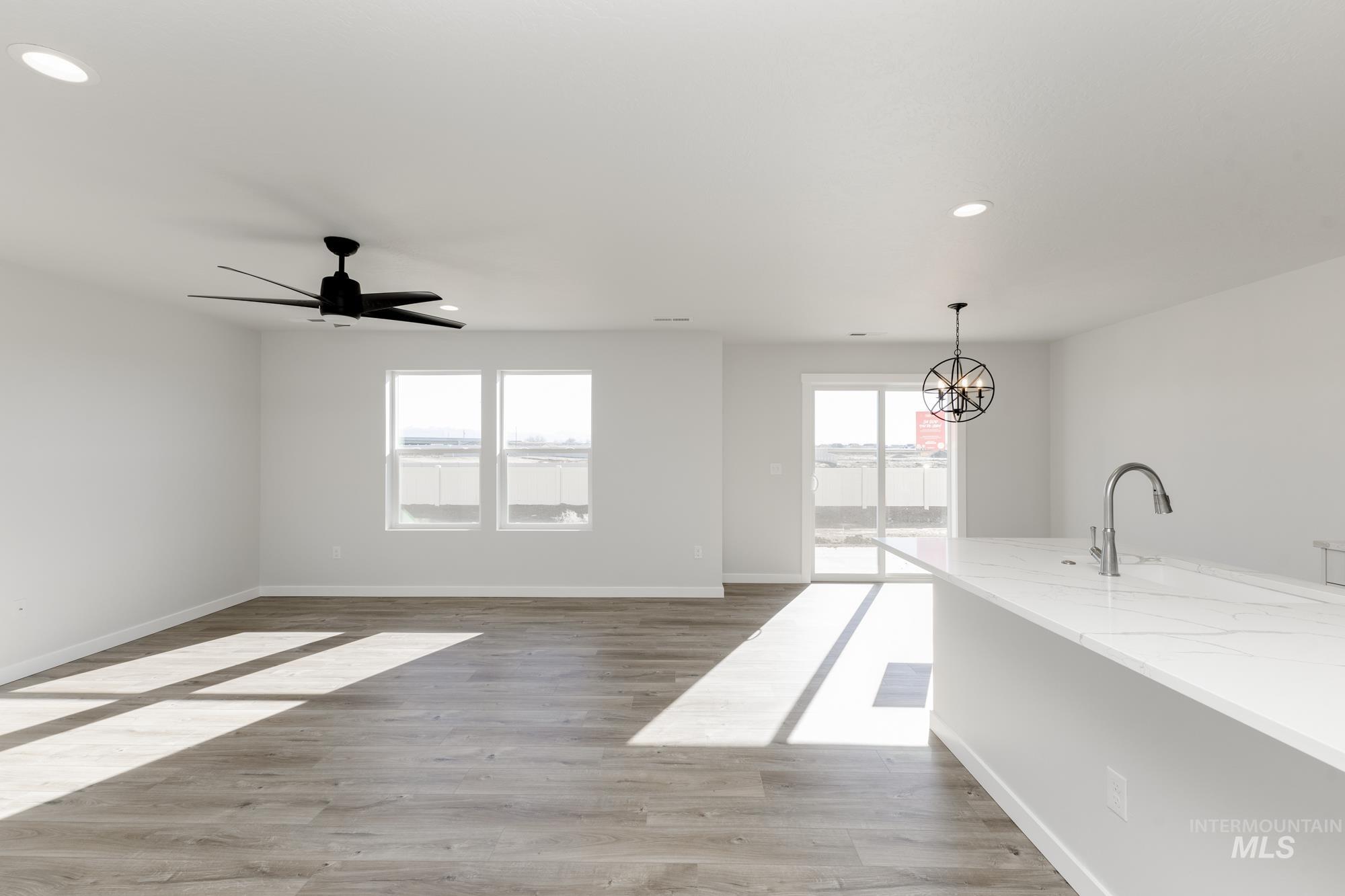 Living room with a chandelier, recessed lighting, light wood-style flooring, and a ceiling fan