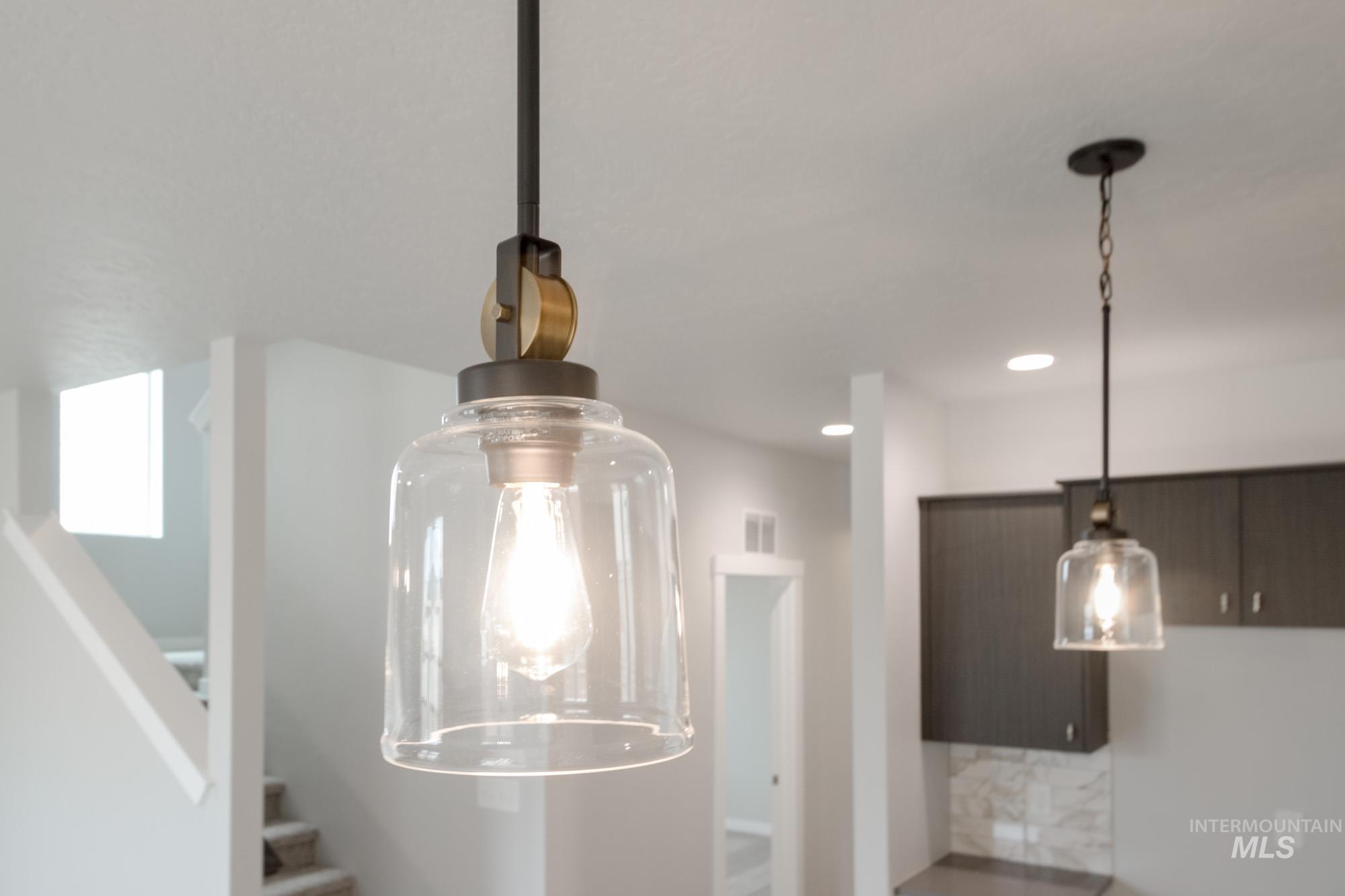 Kitchen view of dark brown cabinets, hanging light fixtures, and recessed lighting
