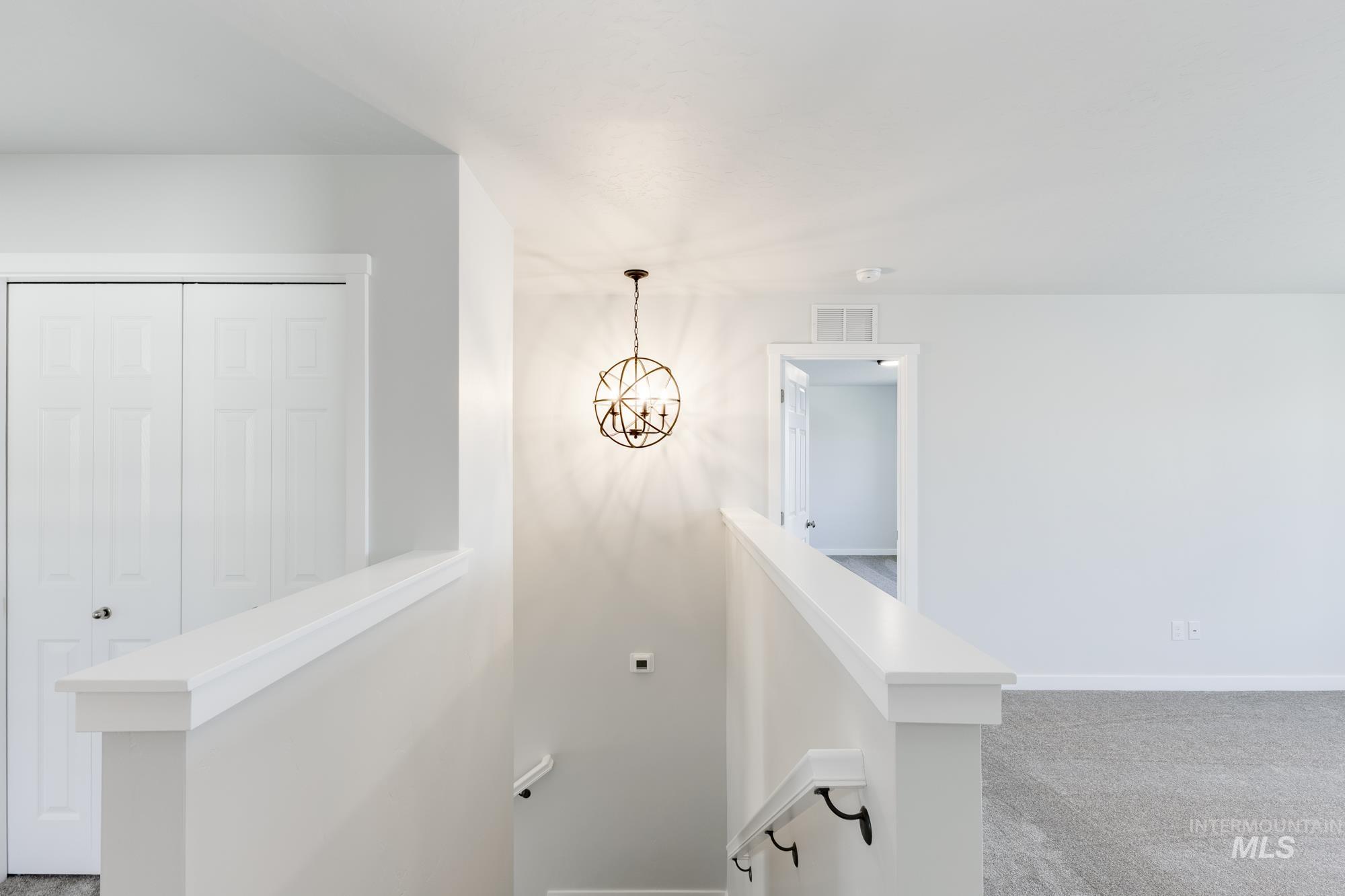 Stairway featuring carpet and a chandelier