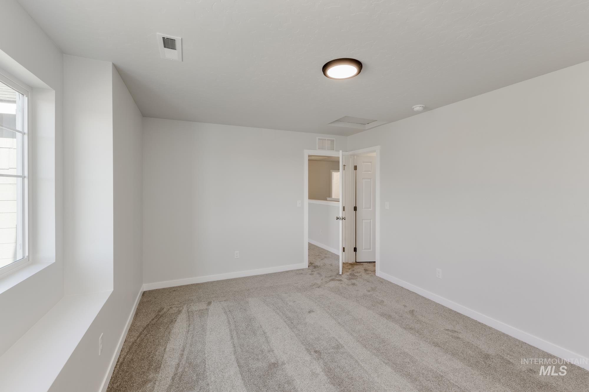 Carpeted spare room with baseboards
