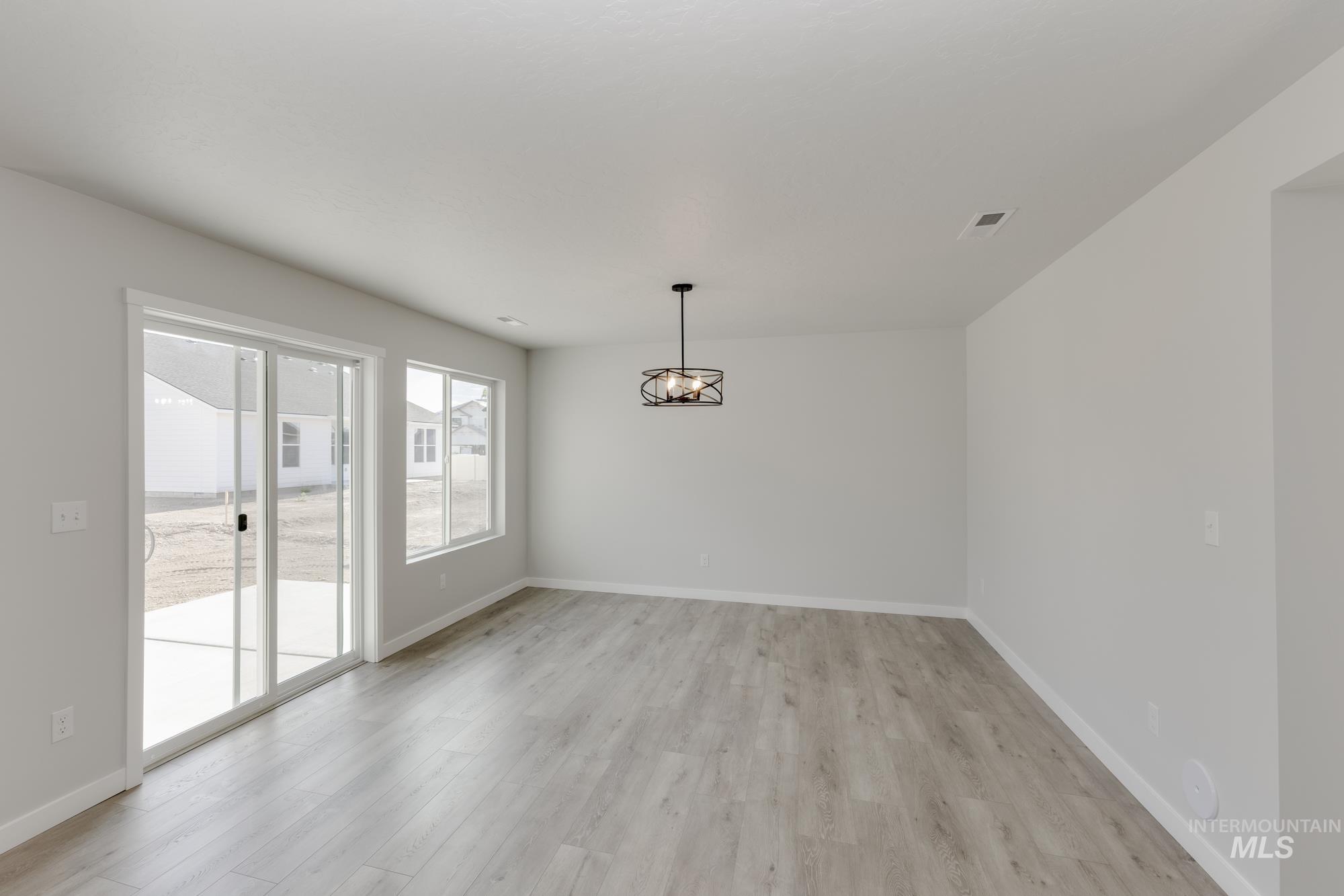 Unfurnished dining area with baseboards and light wood-style flooring