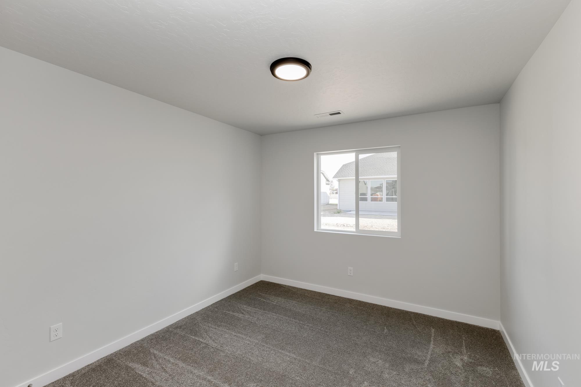 Spare room with dark colored carpet