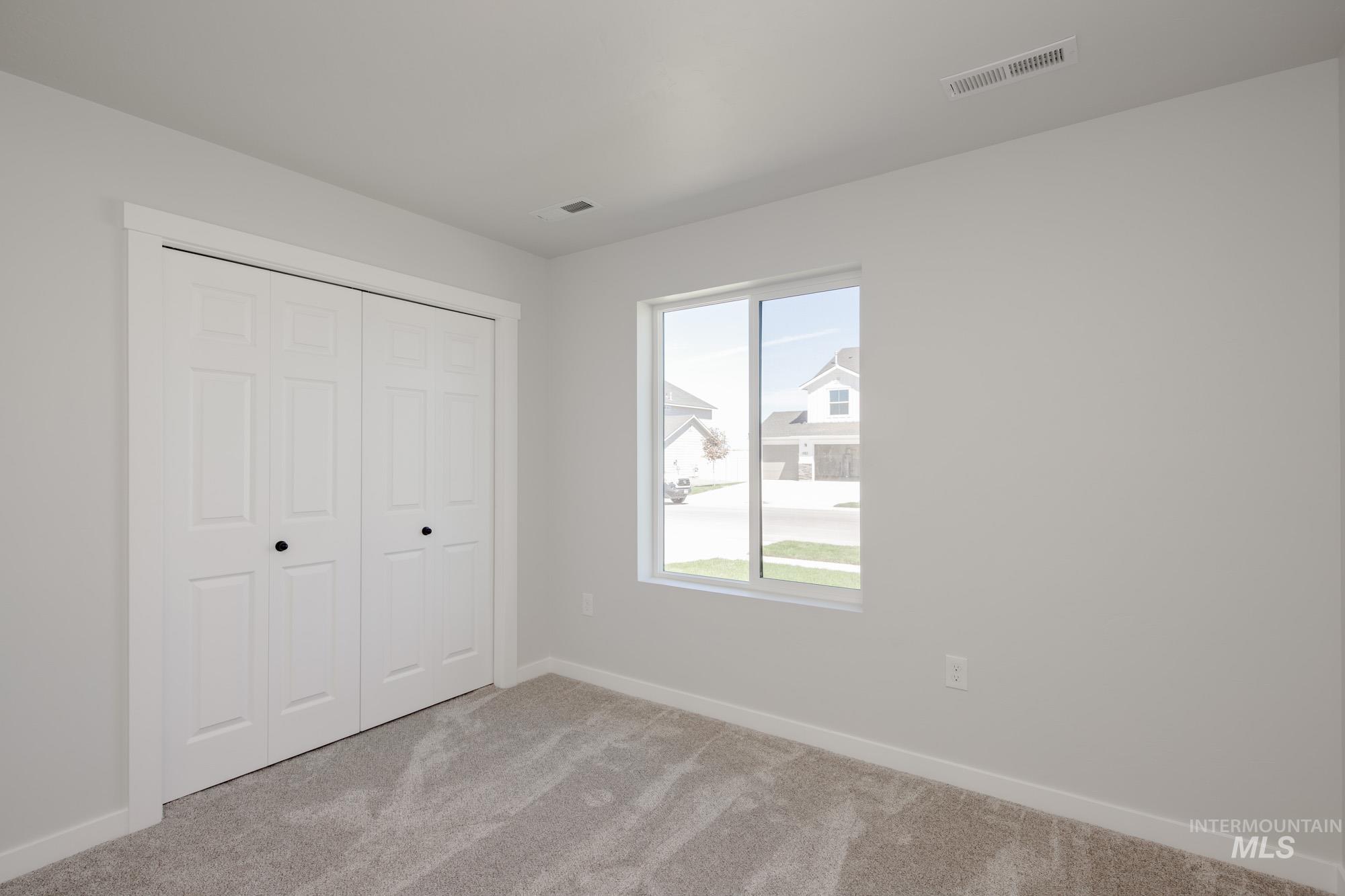 Unfurnished bedroom featuring carpet flooring and a closet
