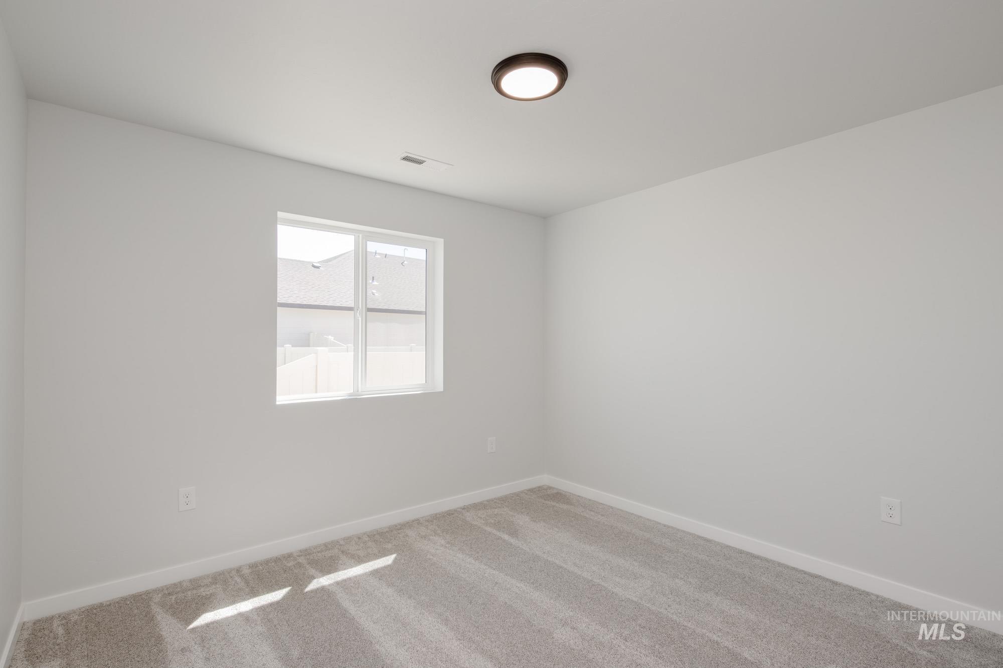 Spare room featuring carpet floors and baseboards