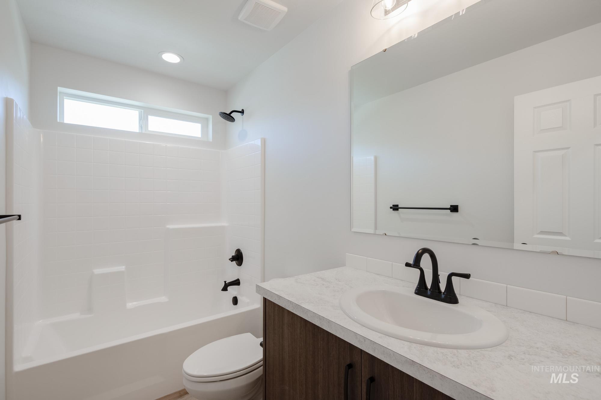 Bathroom with vanity, bathtub / shower combination, and recessed lighting