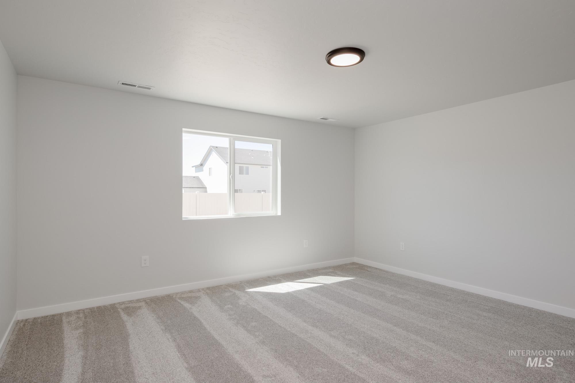 Empty room with carpet floors and baseboards