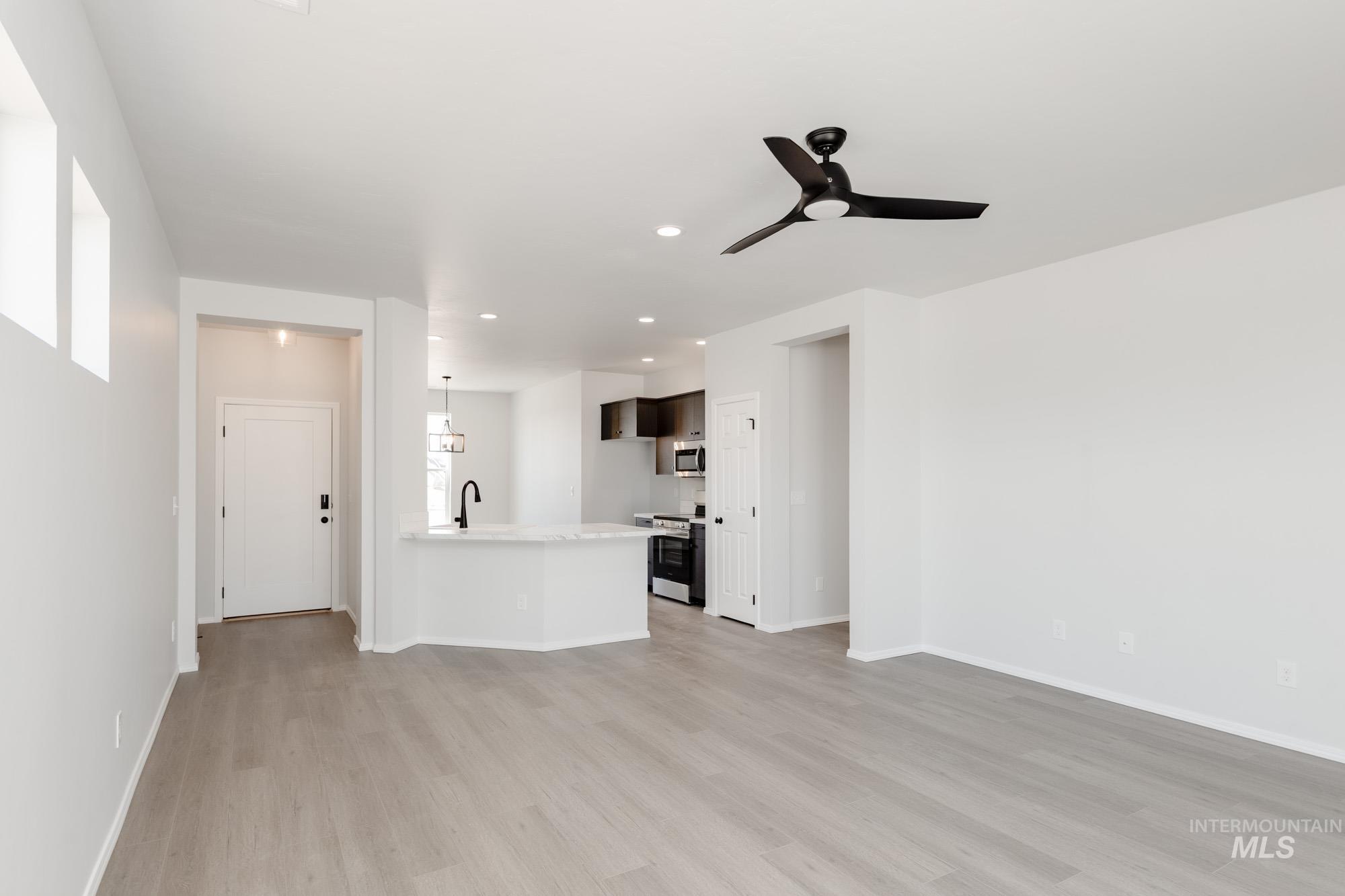 Unfurnished living room featuring light wood-style flooring, recessed lighting, and a ceiling fan